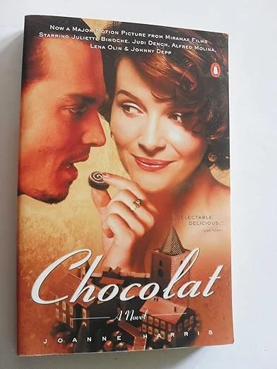 Cover of the book 'Chocolat' featuring a man and woman, with the woman holding a chocolate lollipop and smiling.