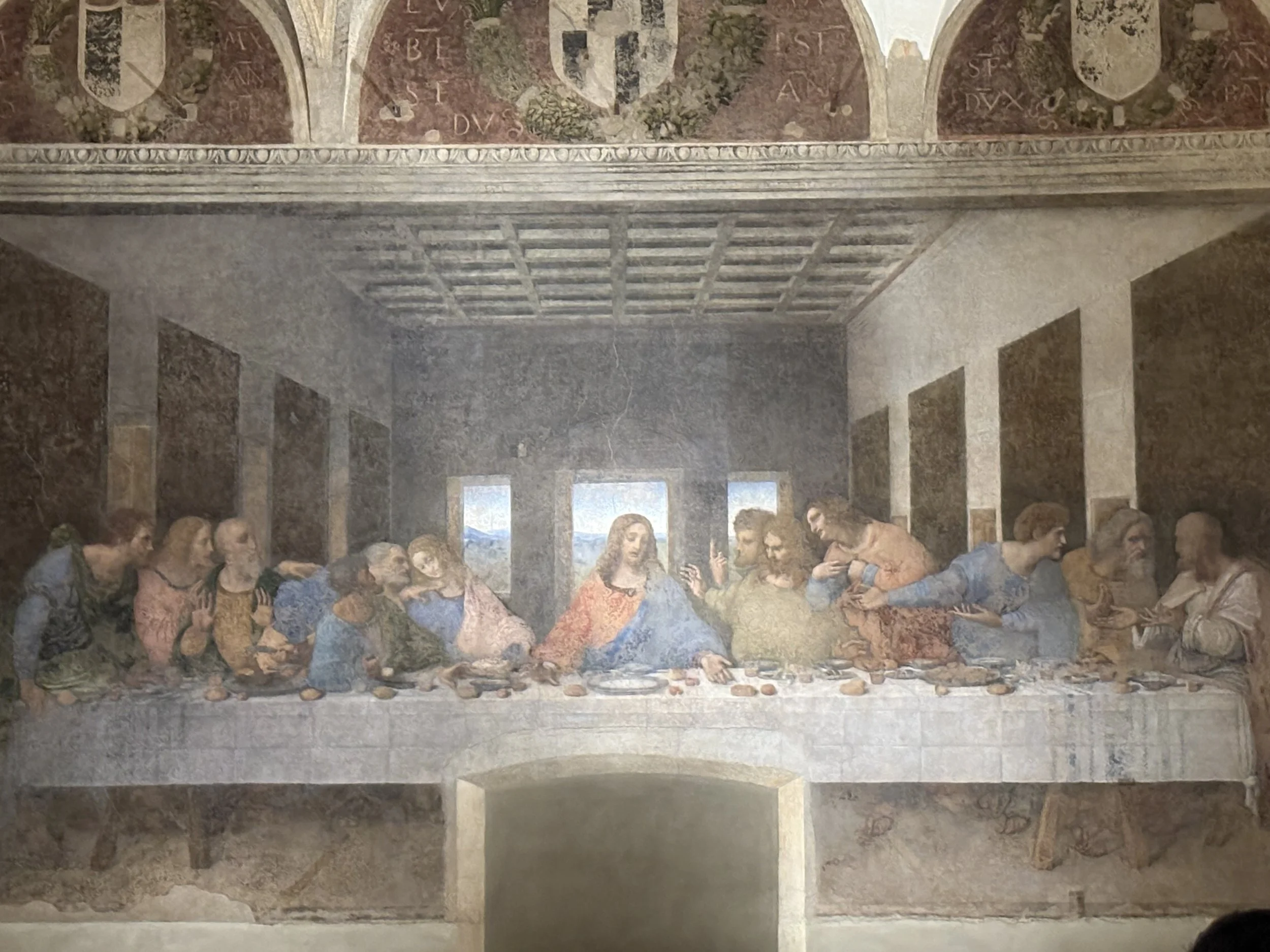 Fresco painting of the Last Supper with Jesus and his twelve apostles sitting at a long table.