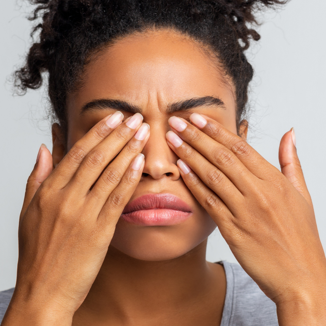 Woman unhappy and covering her eyes with her hands due to painful tear ducts