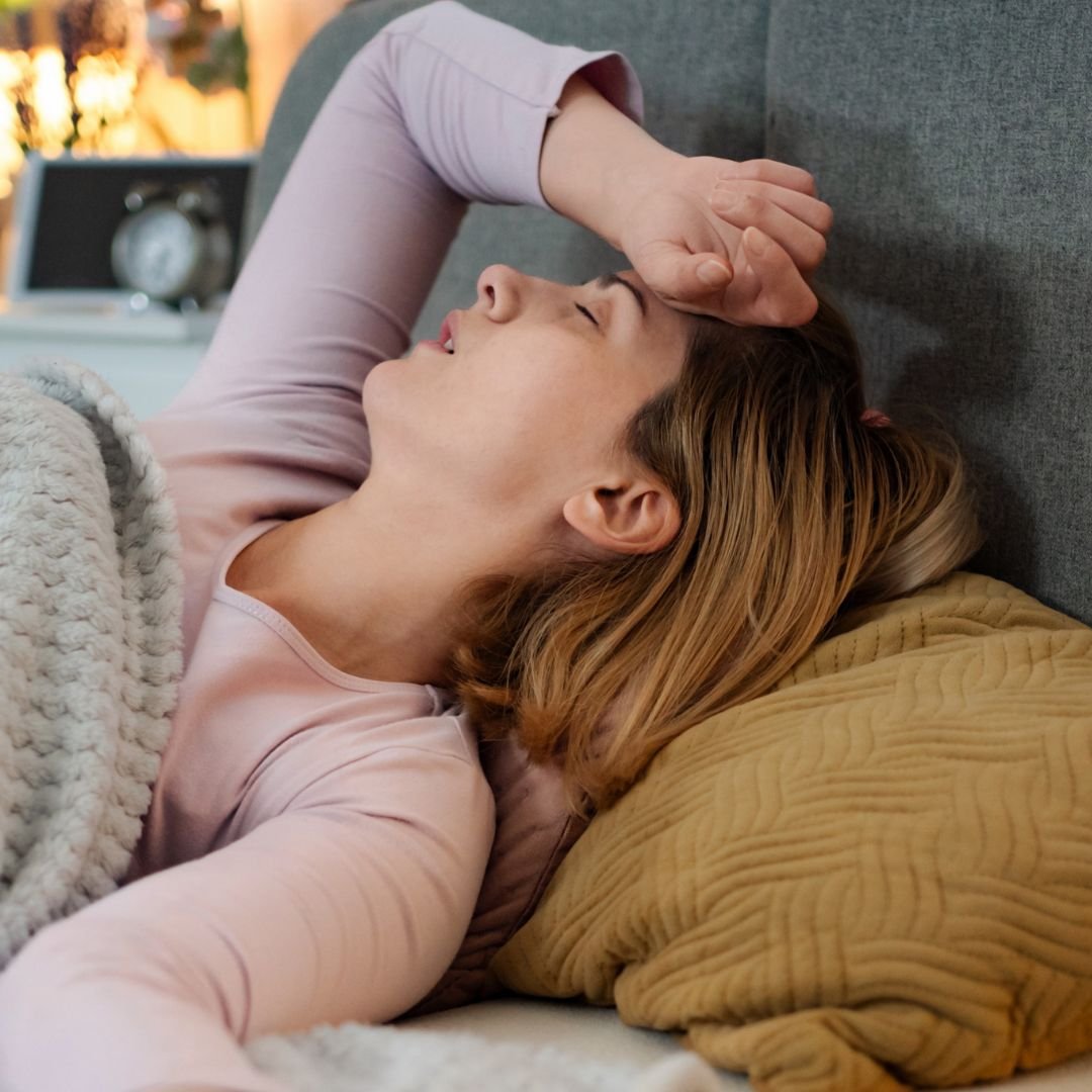 woman with hand over her head struggling to sleep in bed