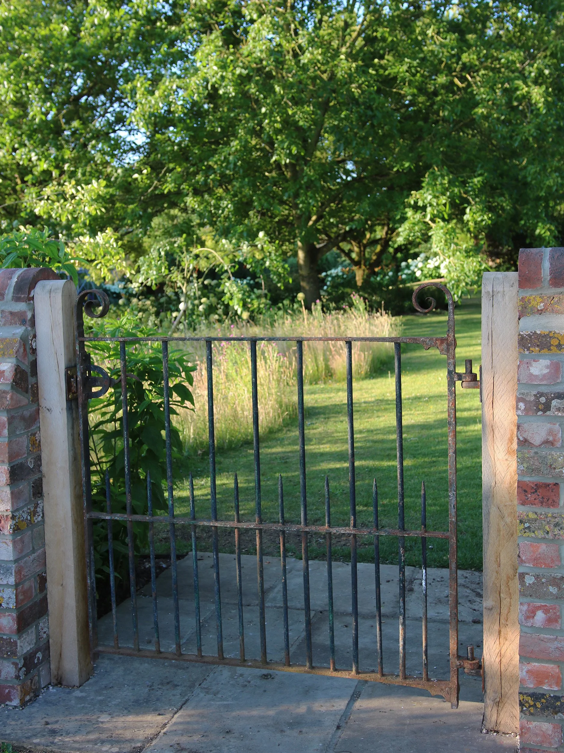 A new reclaimed gate connects the orchard to the meadow. The orchard is mown in squares to create a wildflower parterre to connect the orchard to the meadow beyond.