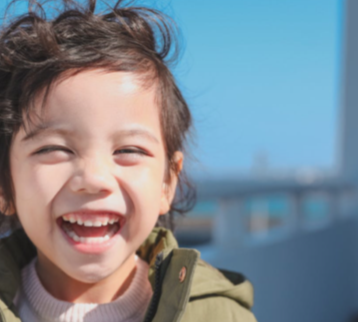 Young girl smiling outdoors on a sunny day