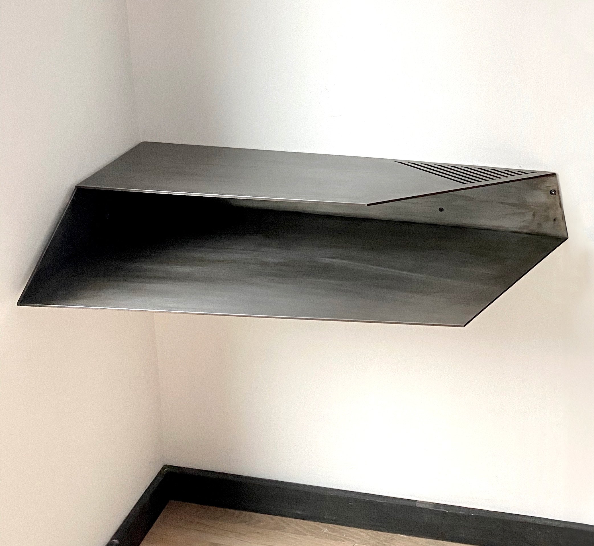 Wall mounted corner desk.
Lacquered Blackened Steel
35" x 17"x 5.5" h
