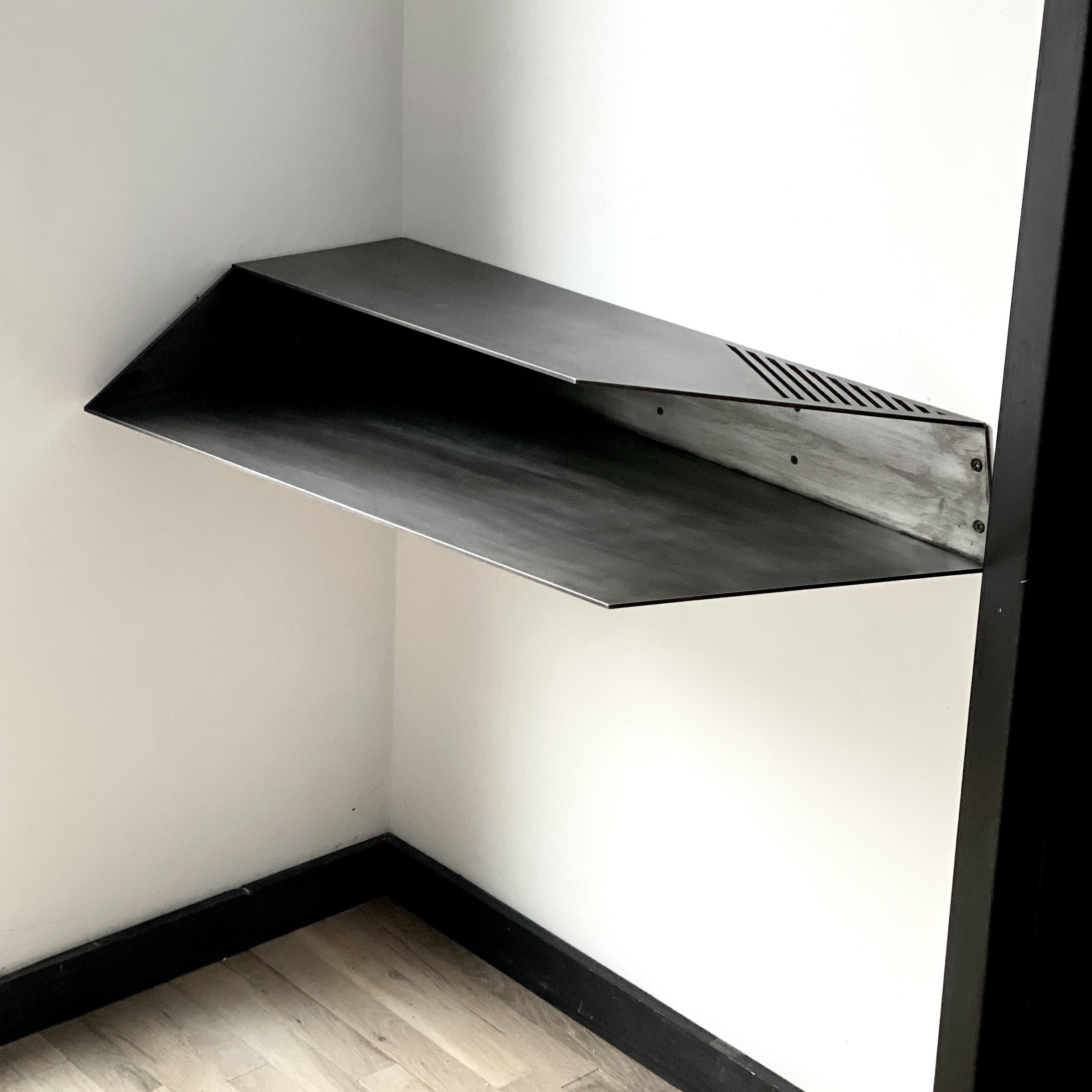 Wall mounted corner desk.
Lacquered Blackened Steel
35" x 17"x 5.5" h