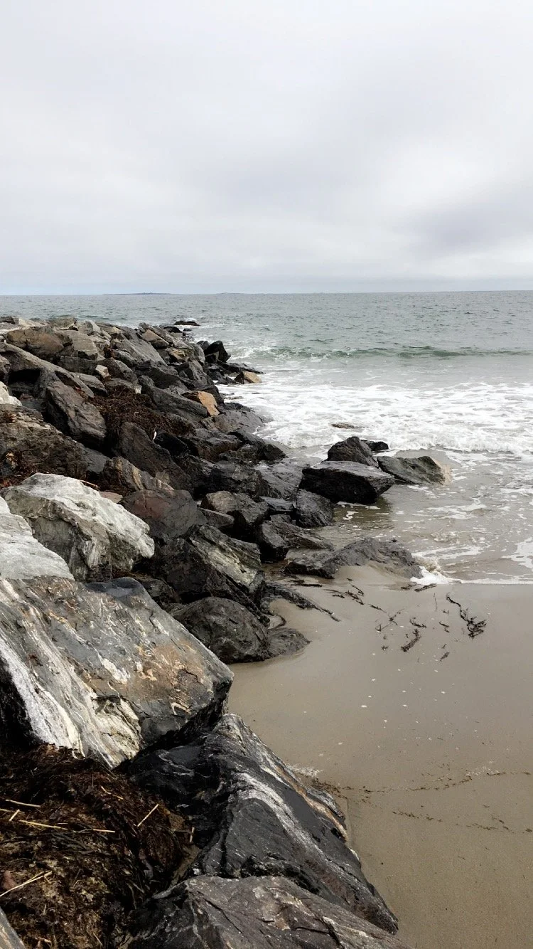 Photo of the rocks leading out to the ocean at Rye Beach
