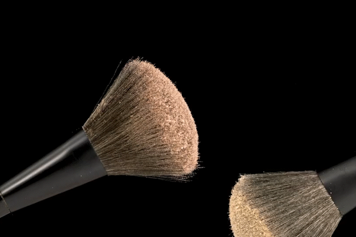 slow motion videographer with beauty product, brush and cosmetic powder captured in slow motion
