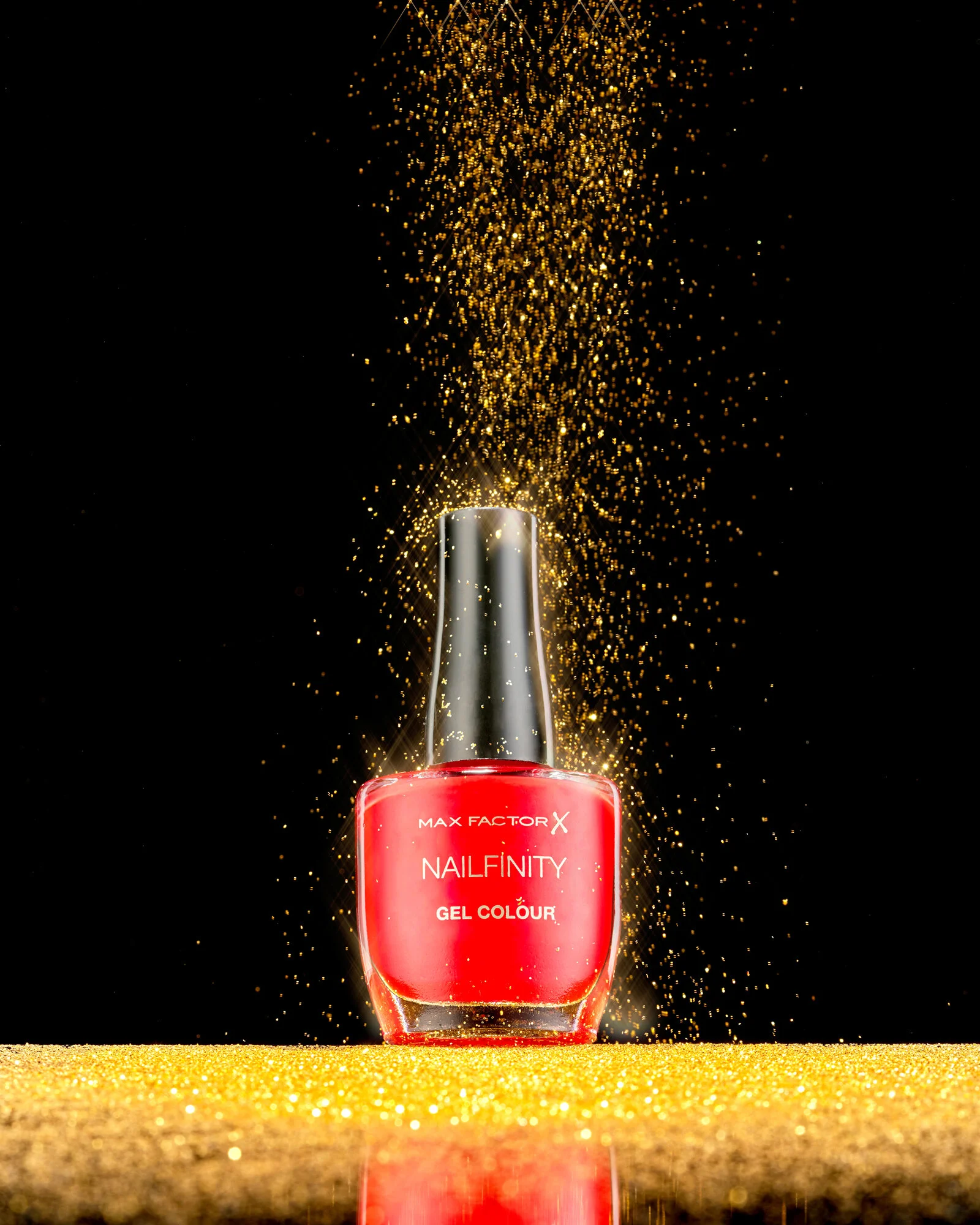 creative product photography with nail varnish beauty product in center of frame with gold cosmetic powdered glitter falling. London beauty packshot (Copy)