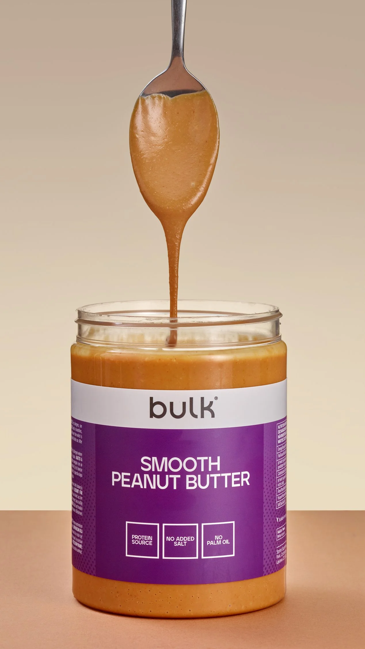 Bulk smooth peanut butter photographed with natural texture and real pouring action.