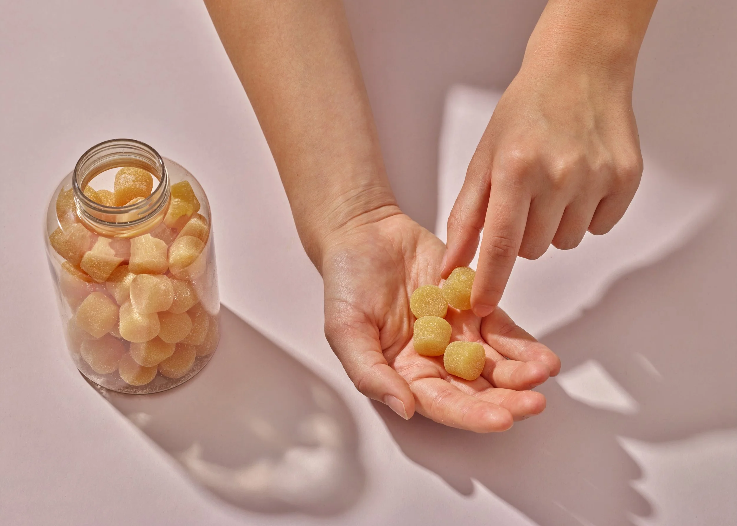 hands holding out and gummies of medical product photography 
