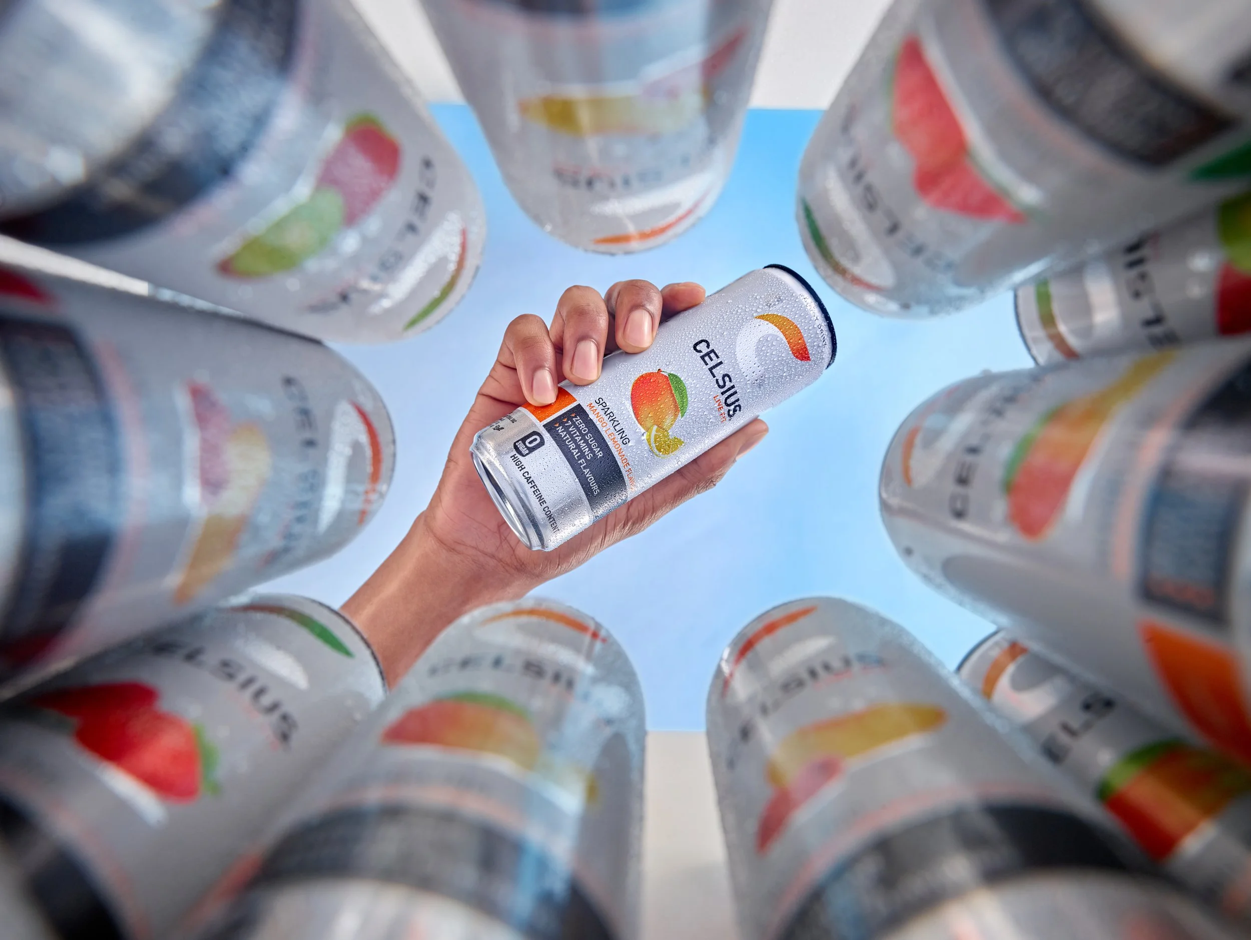 drinks photographer. man hold drinks can over selection of beverages in cool box with sky behind . London food and drinks photographer