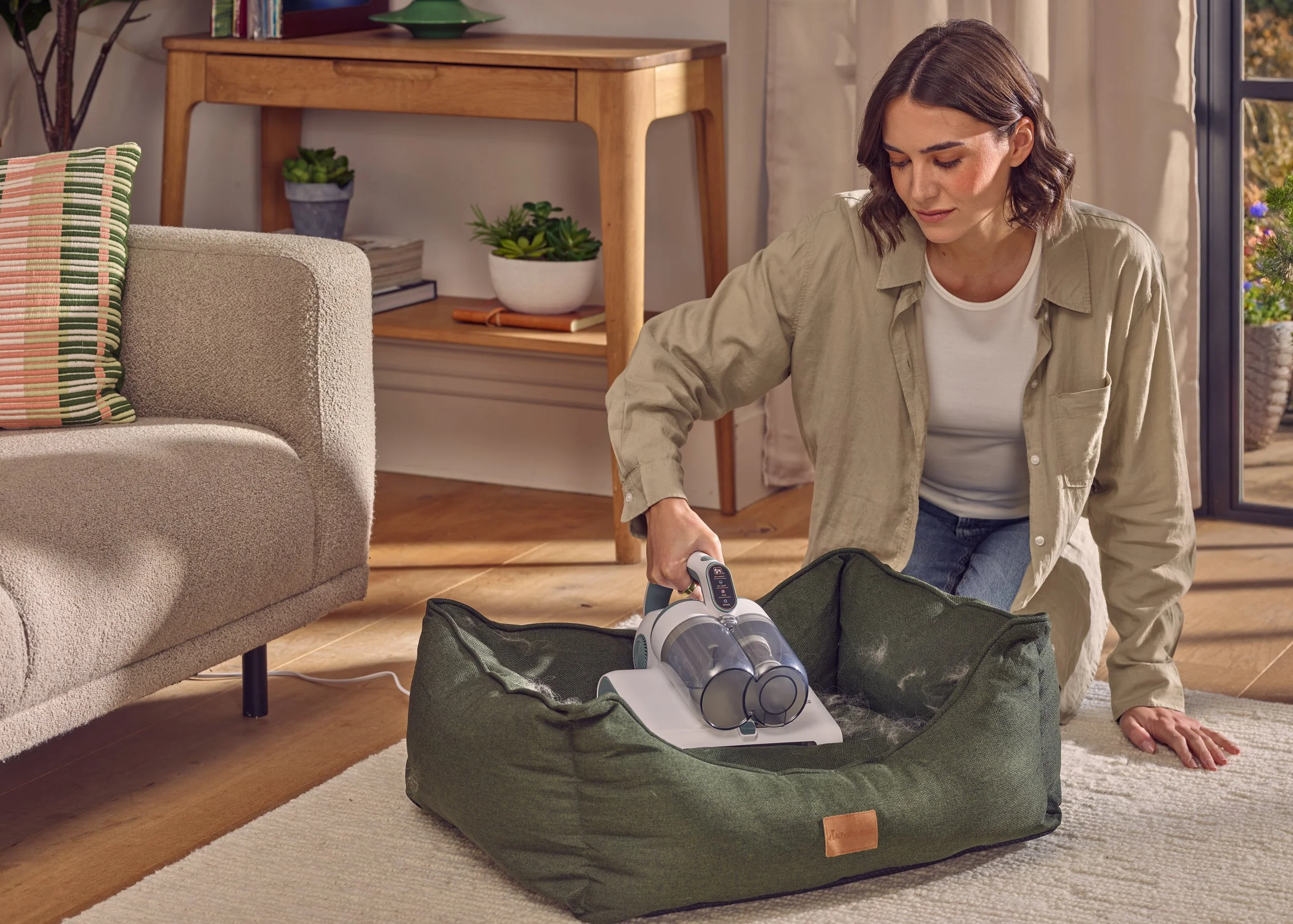 Commercial product photography shot in London location home for advertsing company, Model hoovers pet bed to remove hairs 