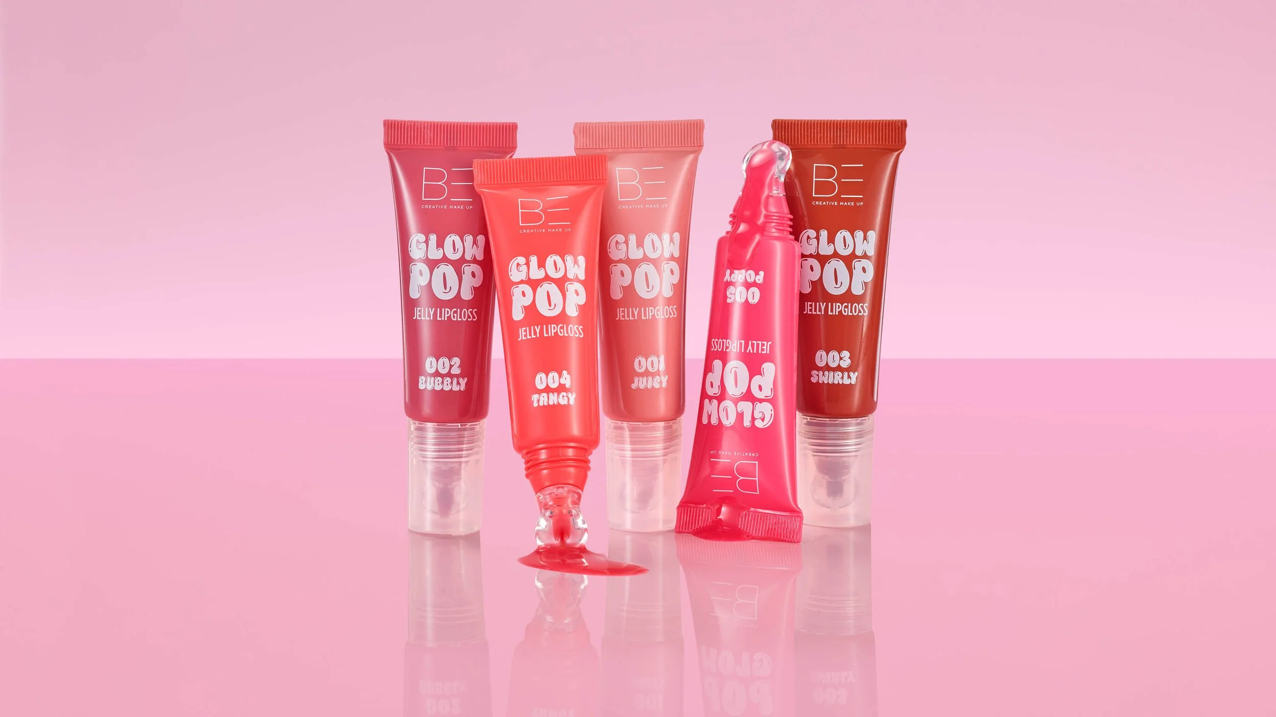 set of 5 glossy lipgloss products together on reflective  perspex
