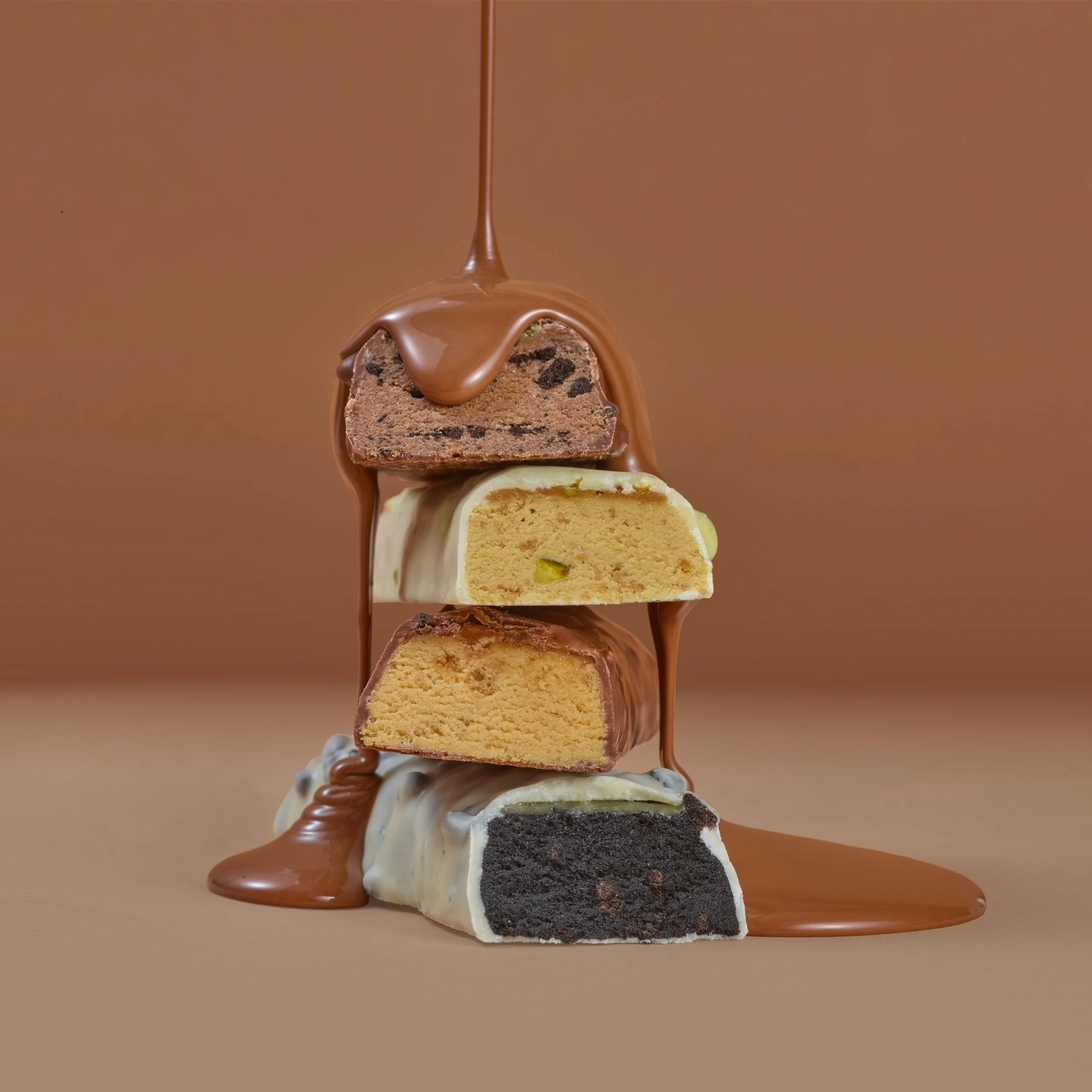 Bulk Maco Munch chocolate bars stacked with liquid chocolate poured over the top with dramatic studio lighting from food photographer Chris Howlett