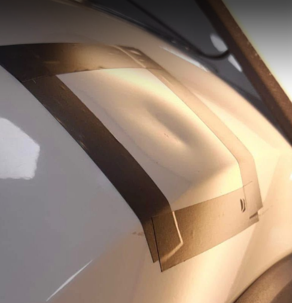 Close-up of a metallic and plastic object with a curved structure, illuminated by a light source.