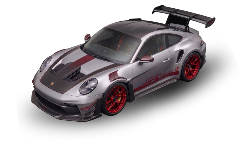 A silver Porsche 911 GT3 racing car with a large rear wing and red wheels, featuring custom graphics and racing modifications.