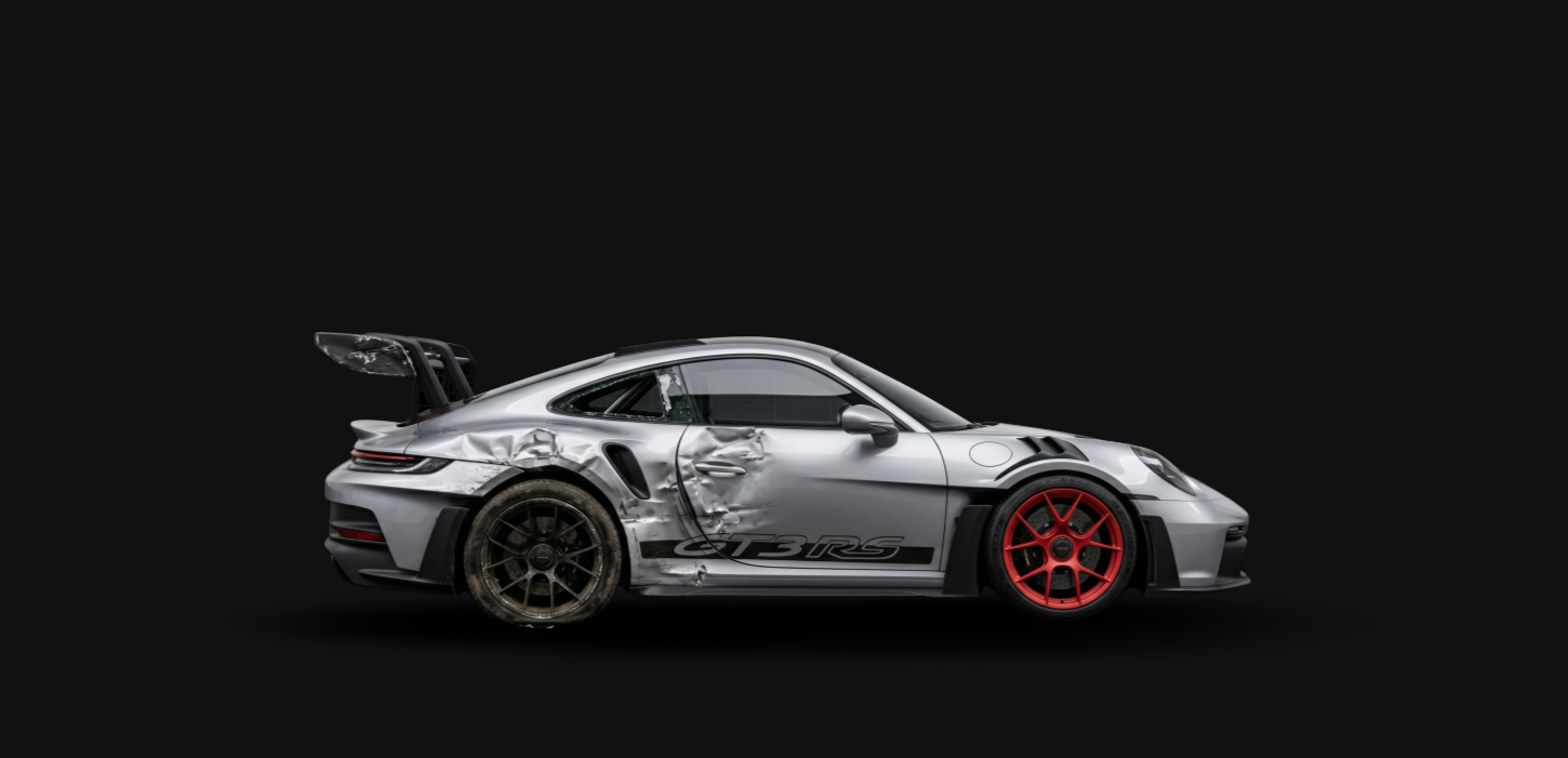 Damaged silver Porsche 911 GT3 RS sports car with a black rear wing, black, and red wheels, set against a black background.