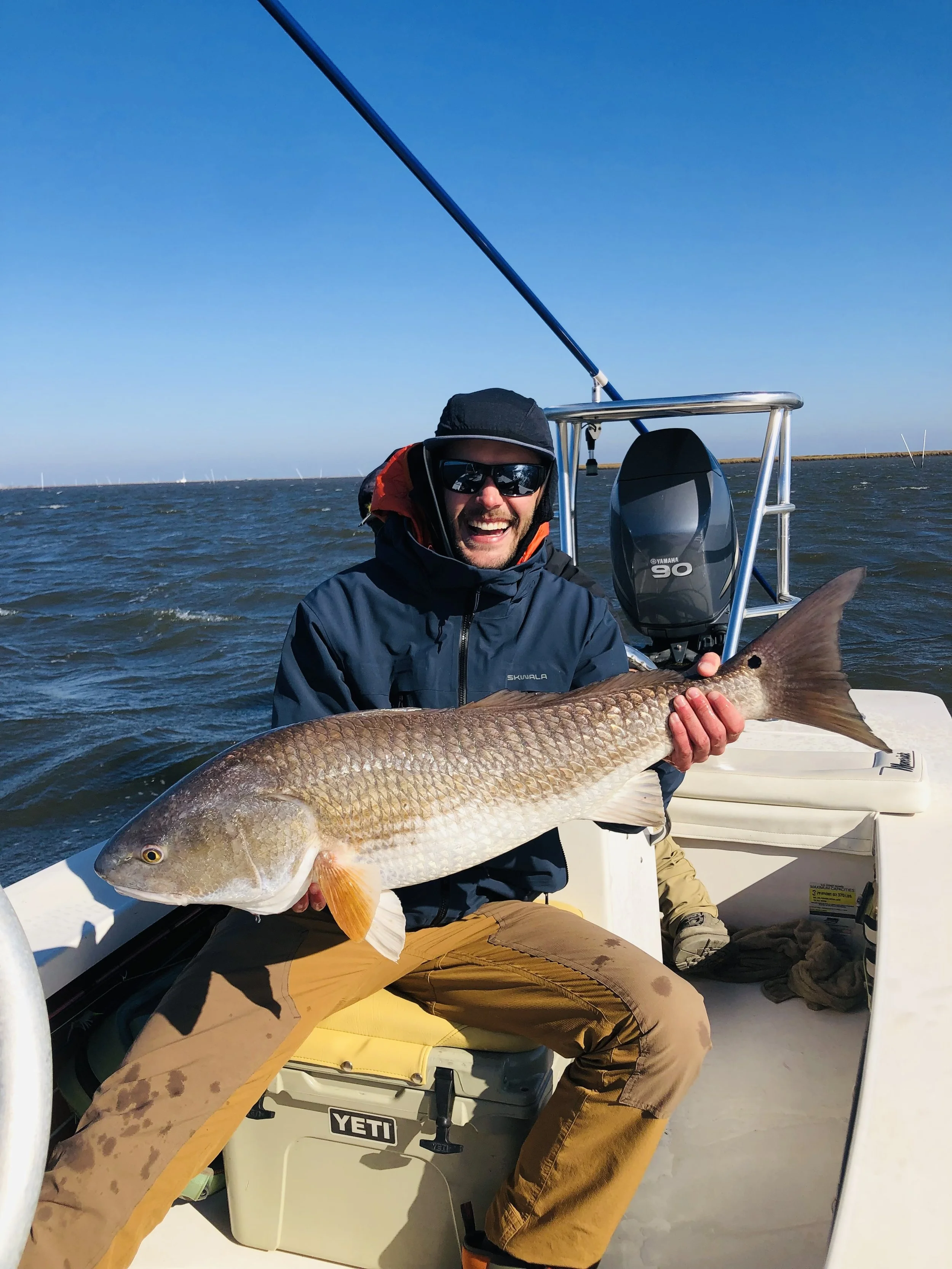 Louisiana fishing guide assisting guest during inshore fishing trip