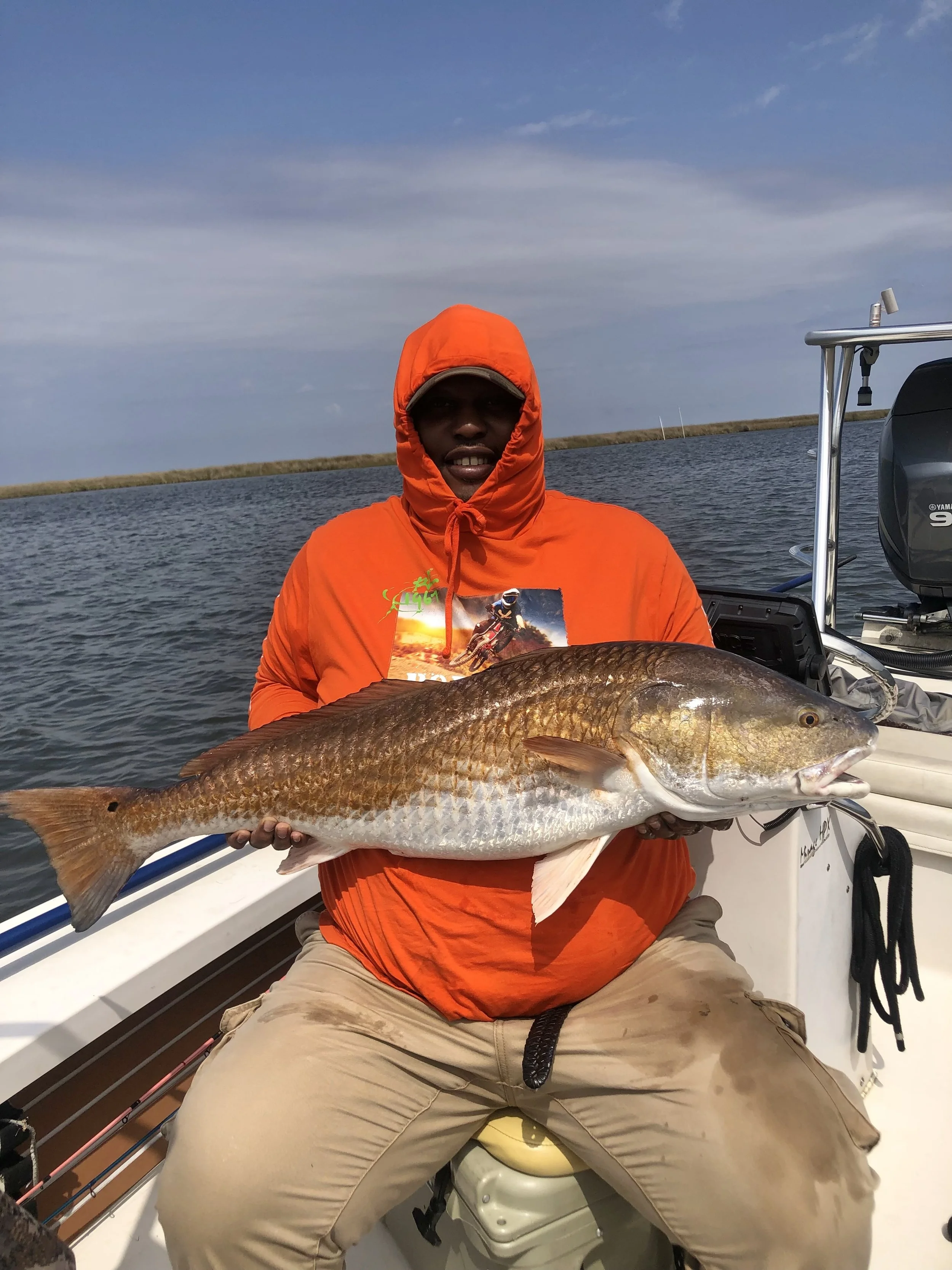 Client holding bull redfish caught spin fishing in Louisiana marsh