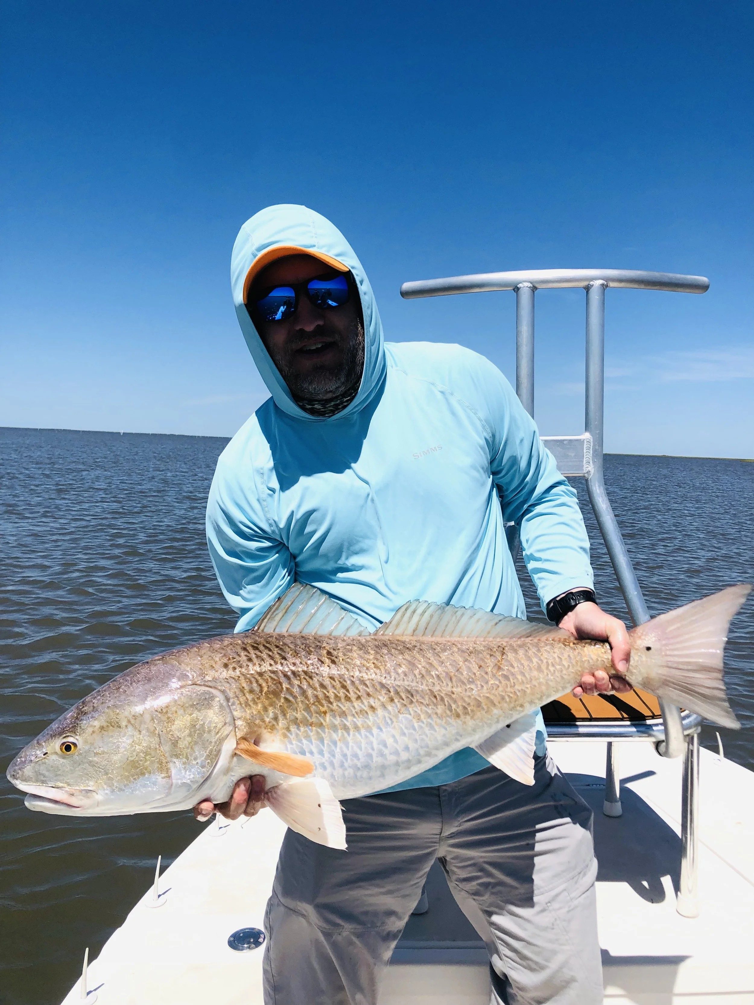 Anglers fishing near marsh grass during Louisiana charter trip