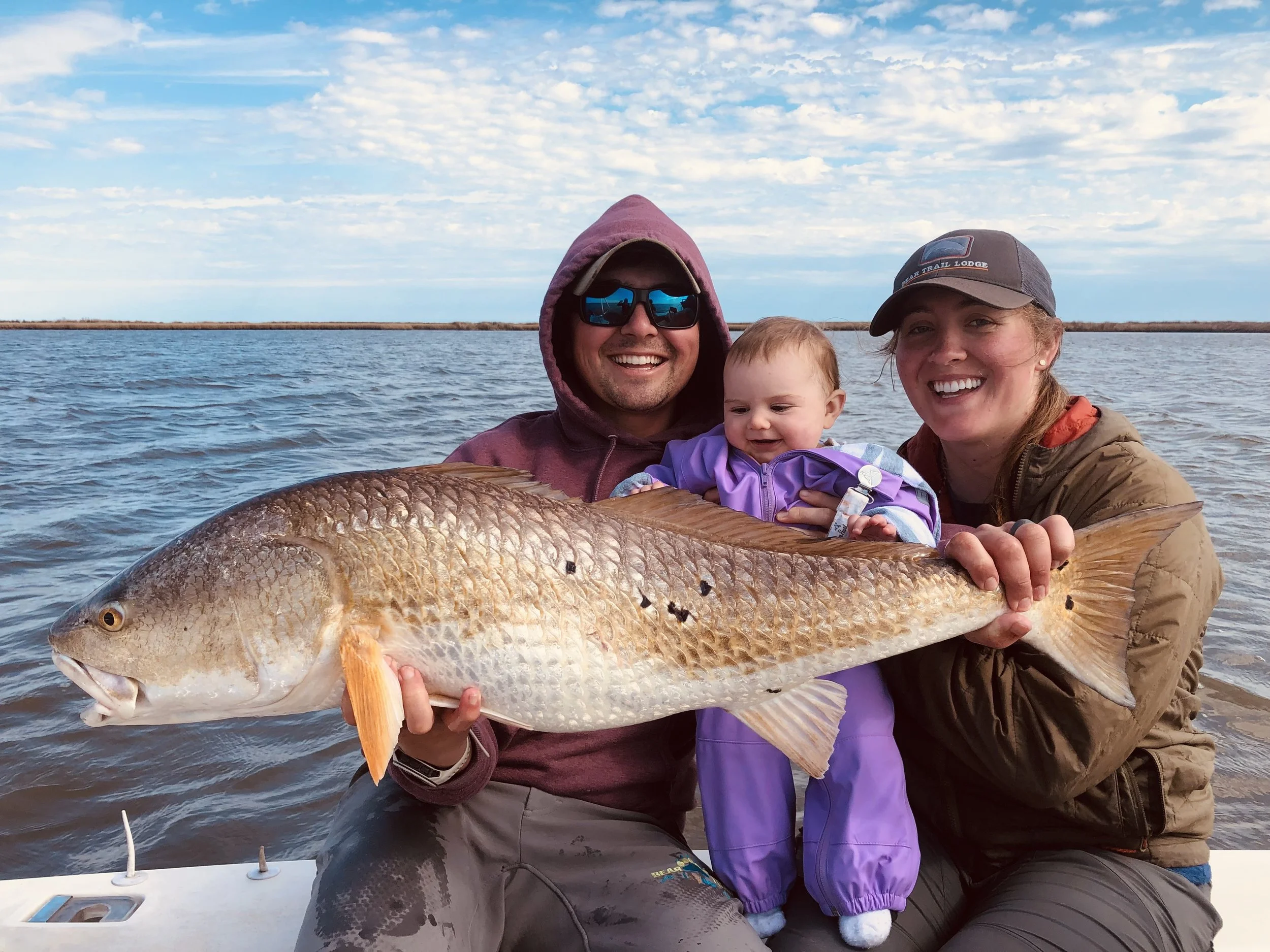 Family enjoying a Louisiana fishing charter with multiple catches