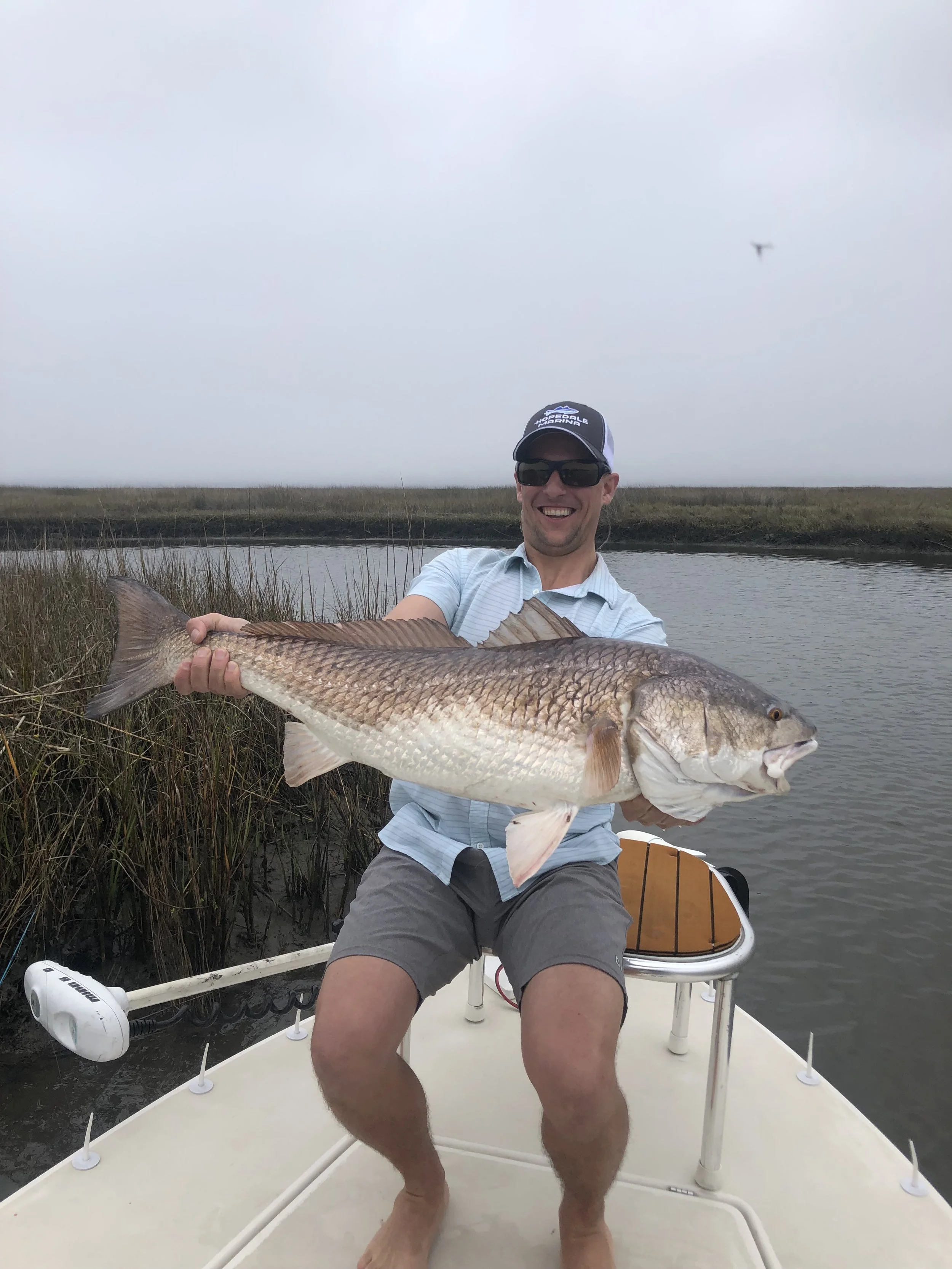 Angler having the time of his life holding huge bull redfish