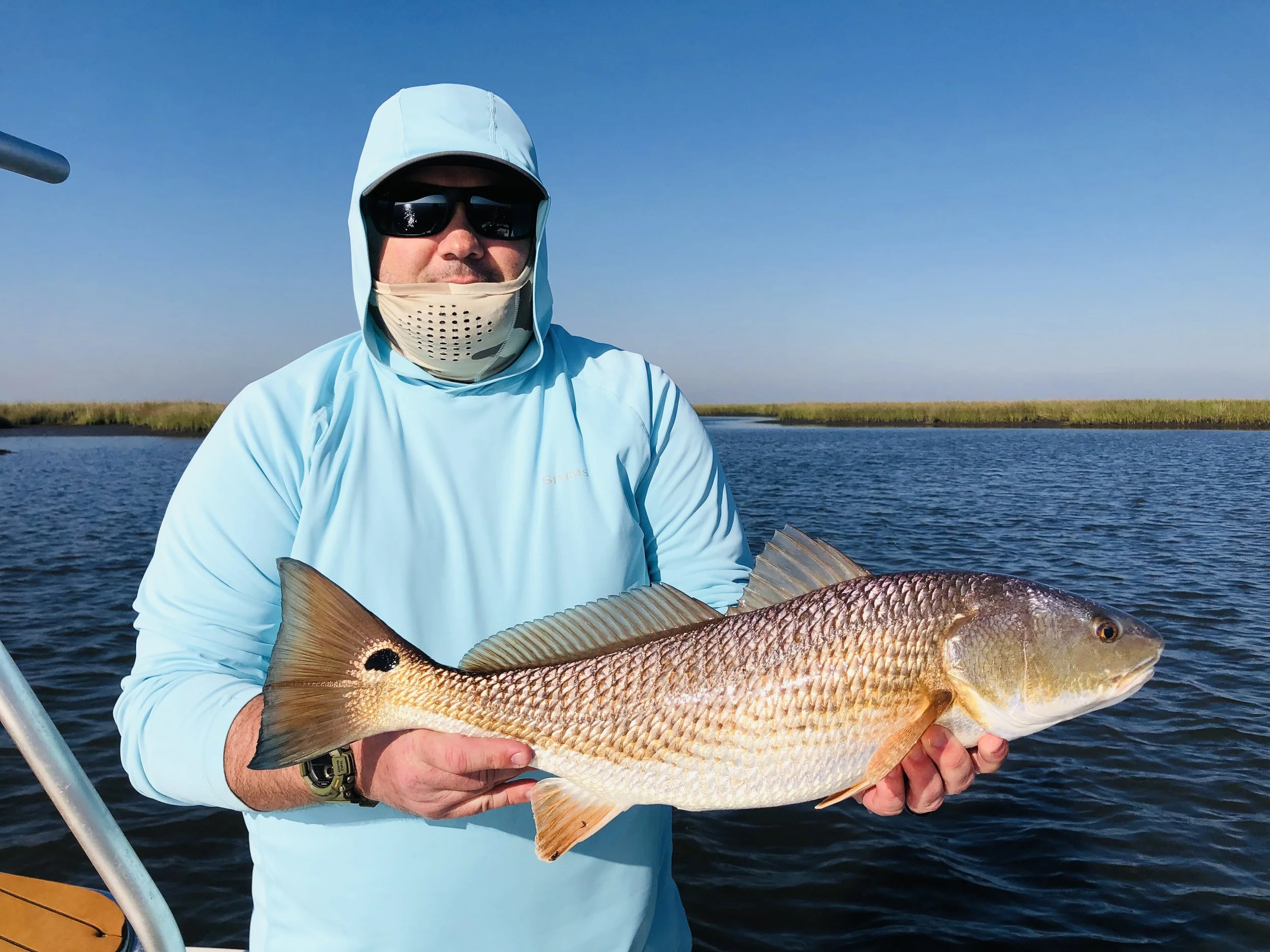 Family enjoying a successful Louisiana fishing charter with multiple redfish catches.
