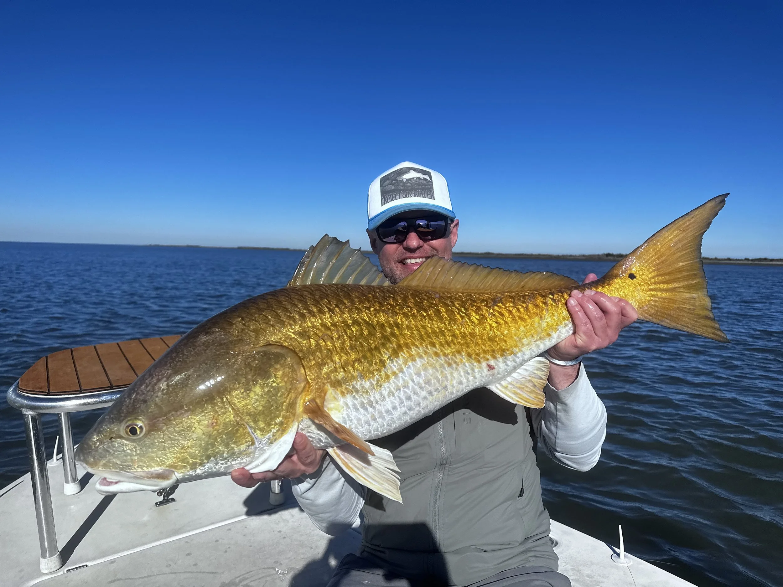 Happy fishing charter clients posing with their Louisiana inshore catch.