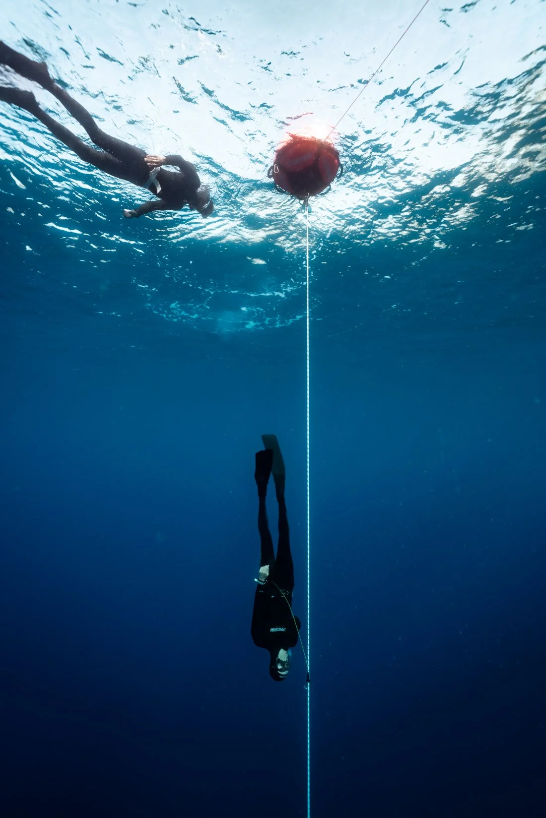 A freediver descending under the supervision of the instructor at the surface in Tenerife