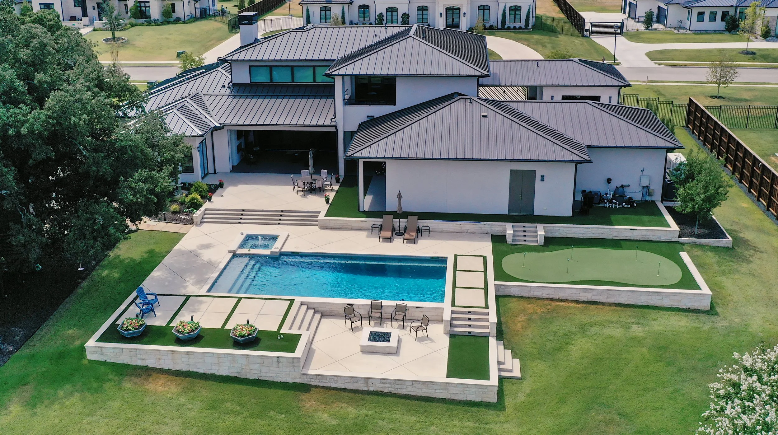 Aerial view of a WillowTree custom home in Southlake, TX with resort-style pool, spa, putting green, and fire pit patio.