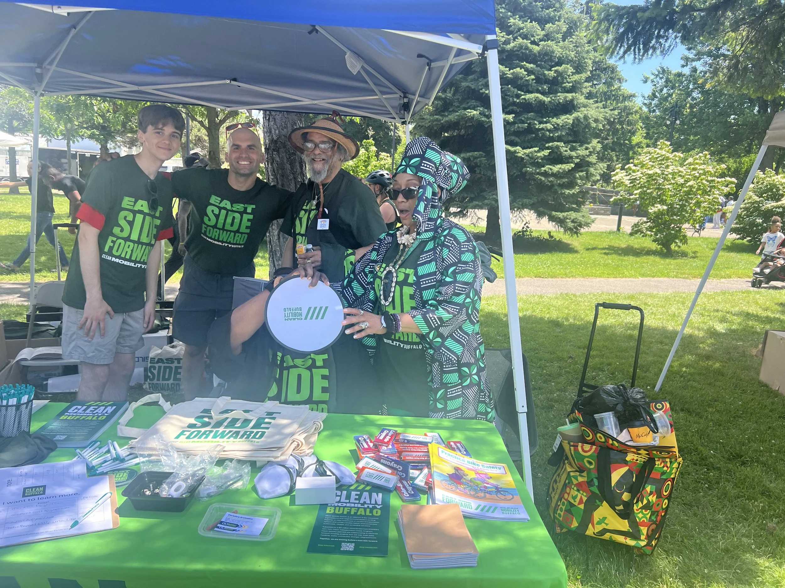 An image of four people at an event smiling and representing Clean Mobility Buffalo.