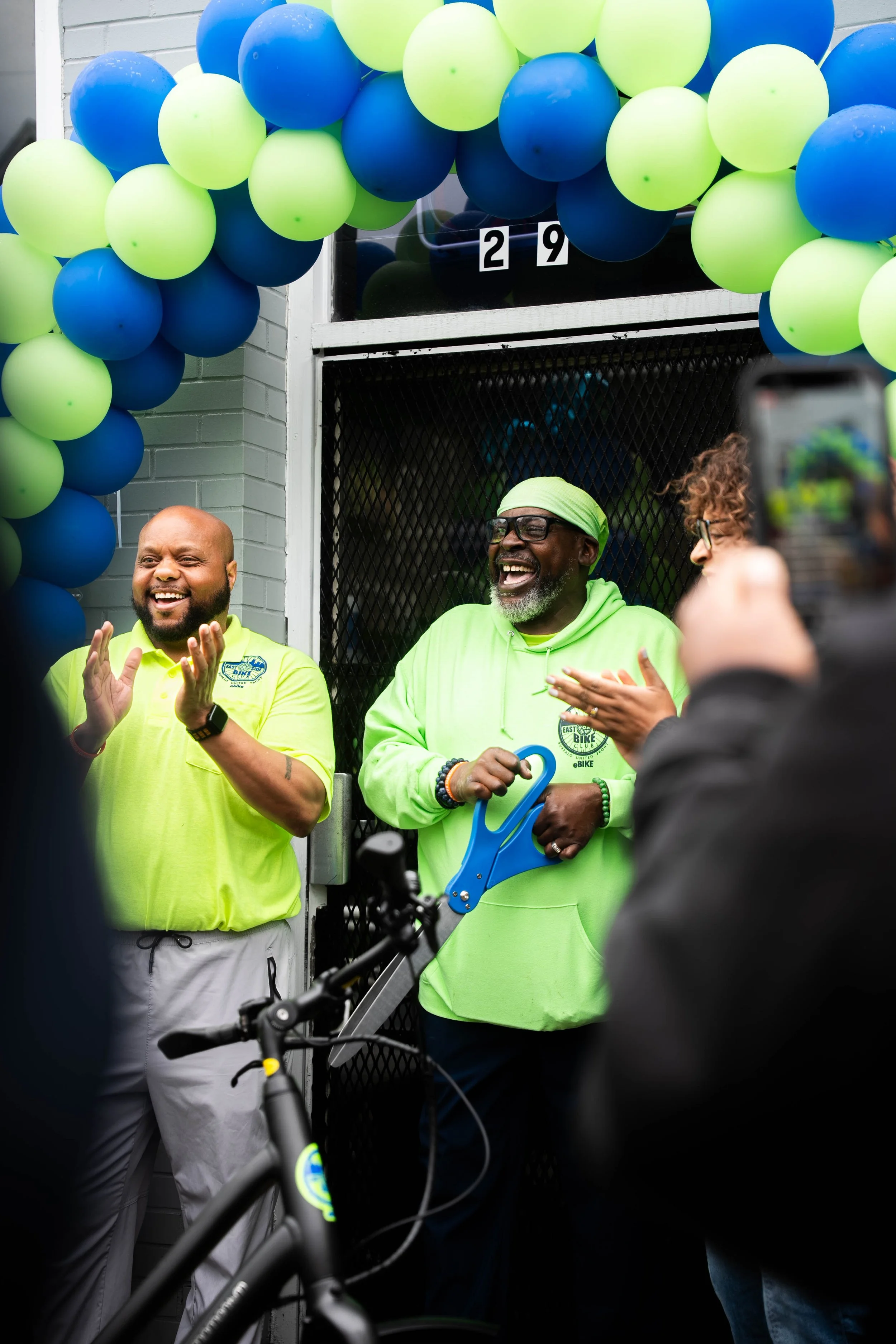 East Side Bike Club E-bike Library Grand opening — An image of East Side Bike Club's founder, George Johnson, cutting a blue ribbon for the bike shops grand opening.