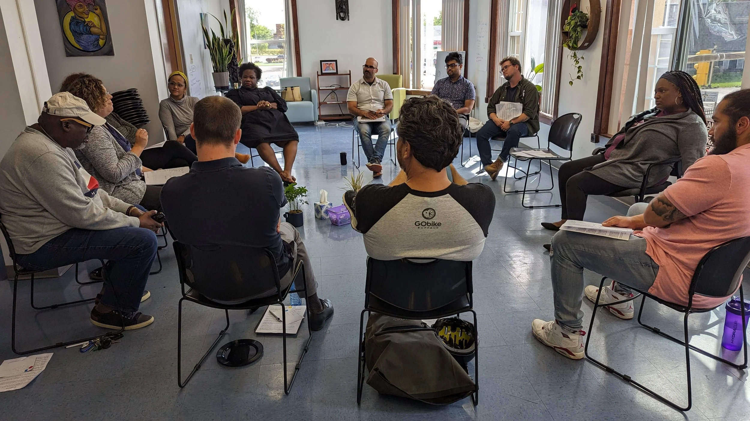 Racial Healing Circles group exercise — A photo of a group of people sitting in fold out chairs in a circle. 