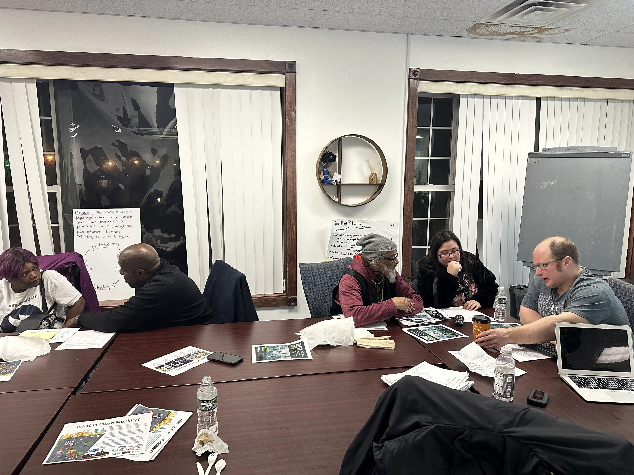 
Neighborhood Leadership Group Meeting 1/31 — an image of a group of people sitting at a desk speaking to each other.