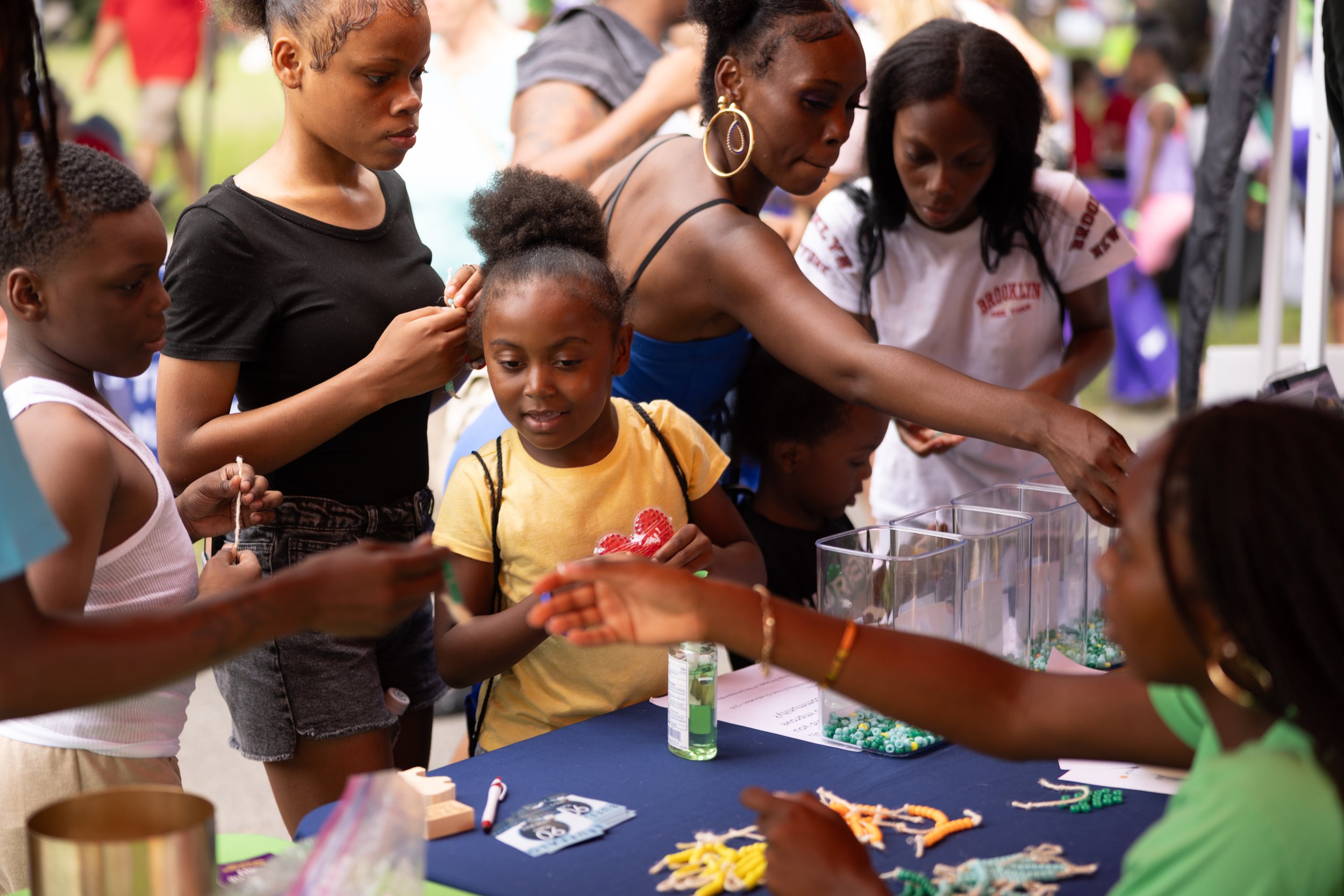 716 Community Day — Kids smiling looking at materials on a table