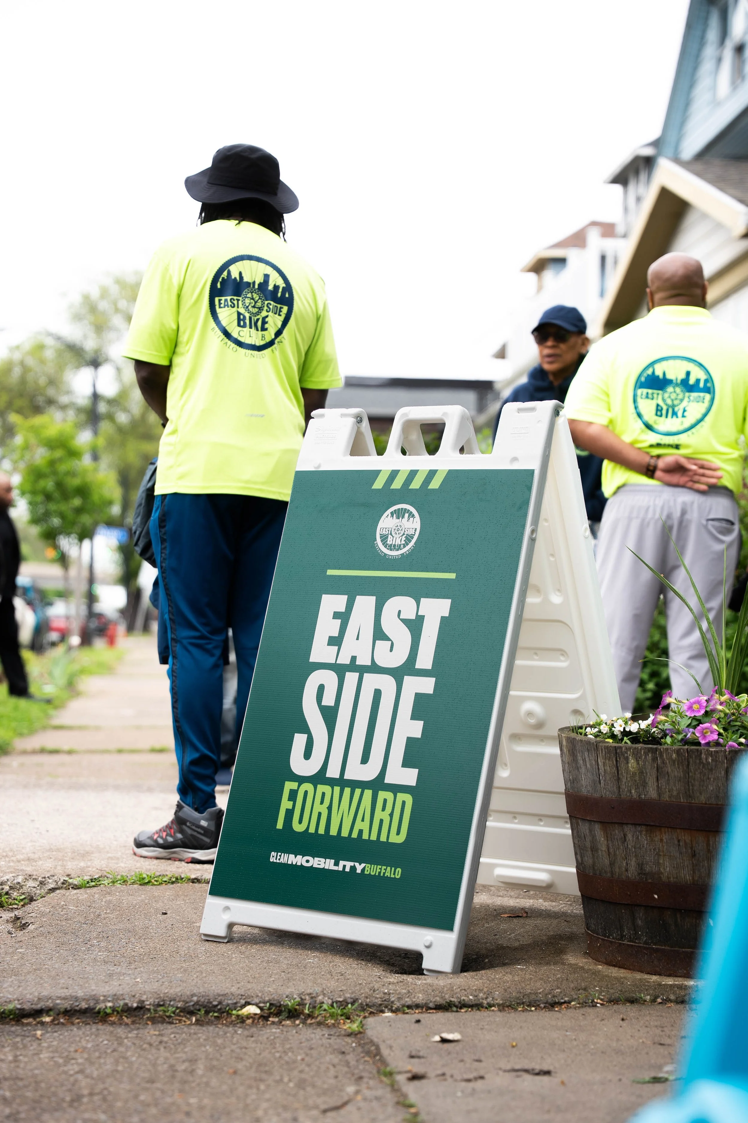 East Side Bike Club E-bike Library Grand opening — A sandwich board that says "EAST SIDE FORWARD" 
