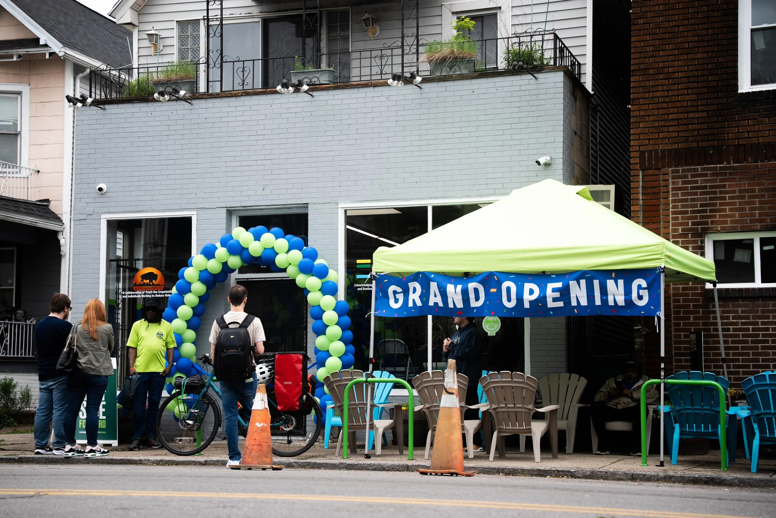 East Side Bike Club E-bike Library Grand opening — An image of the outside of the bike shop with a big blue banner reading "GRAND OPENING" 