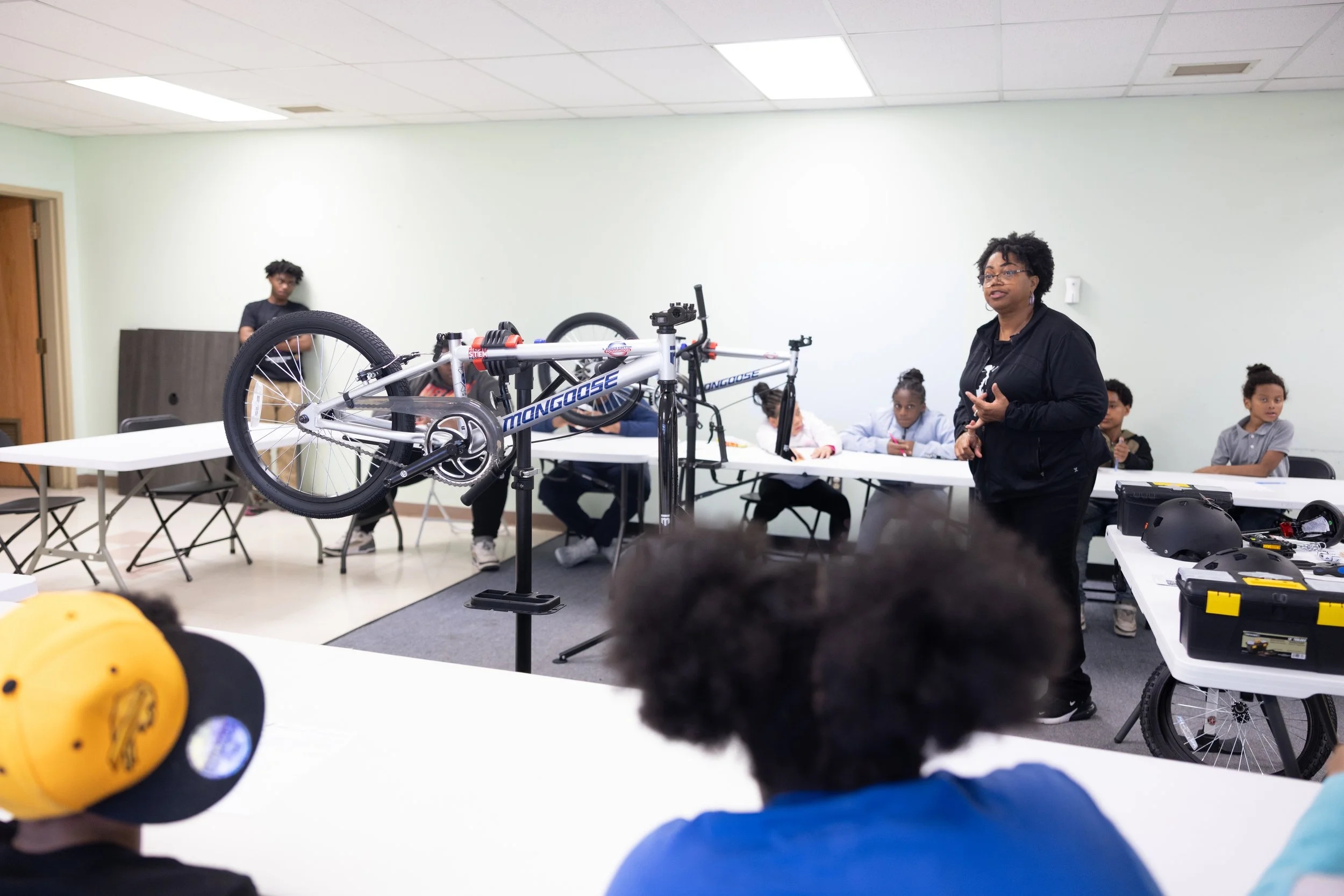 Build-A-Bike 5/29/25 — A women teaching how to build a bike to a class