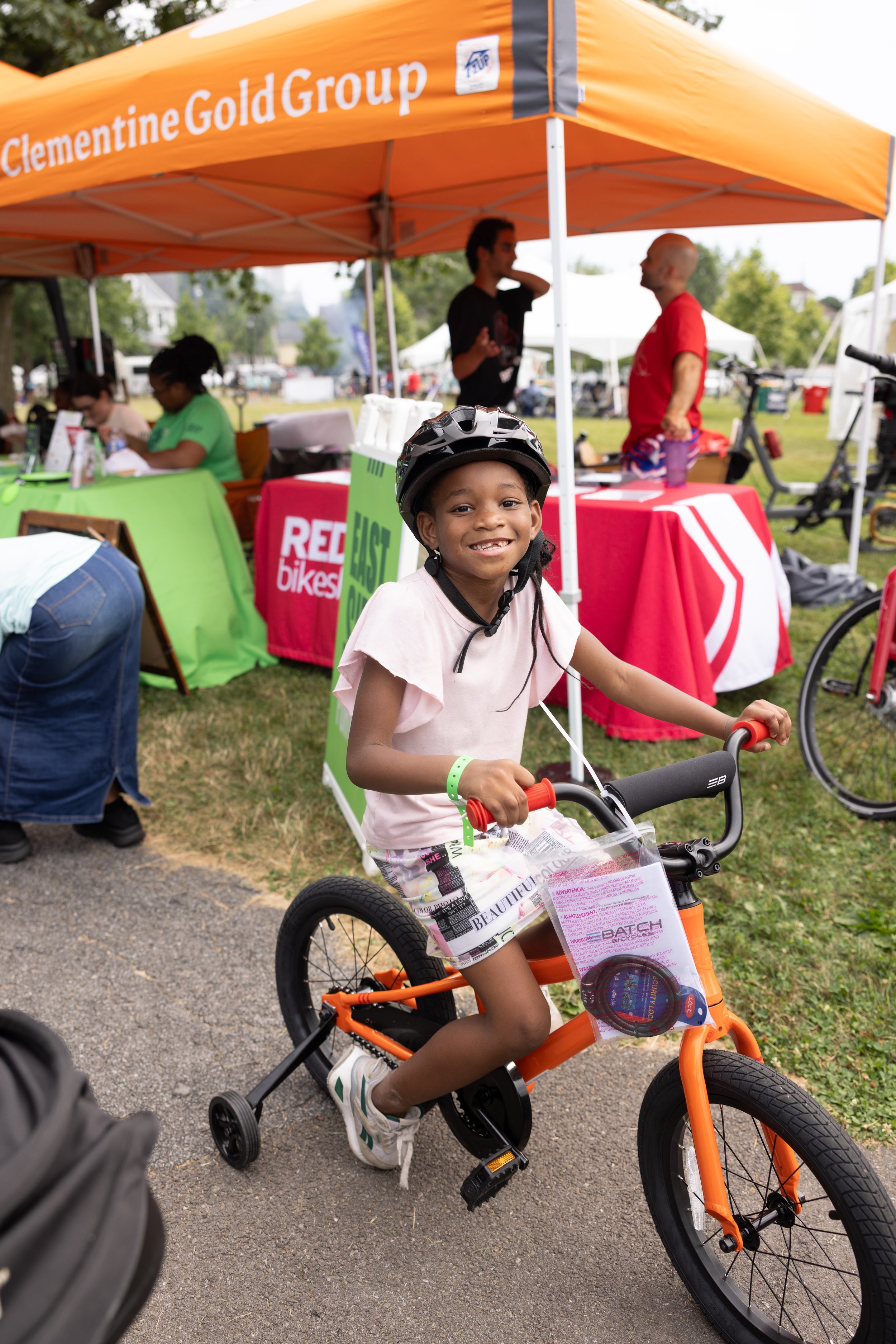 716 Community Day — an image of a child on a bike smiling