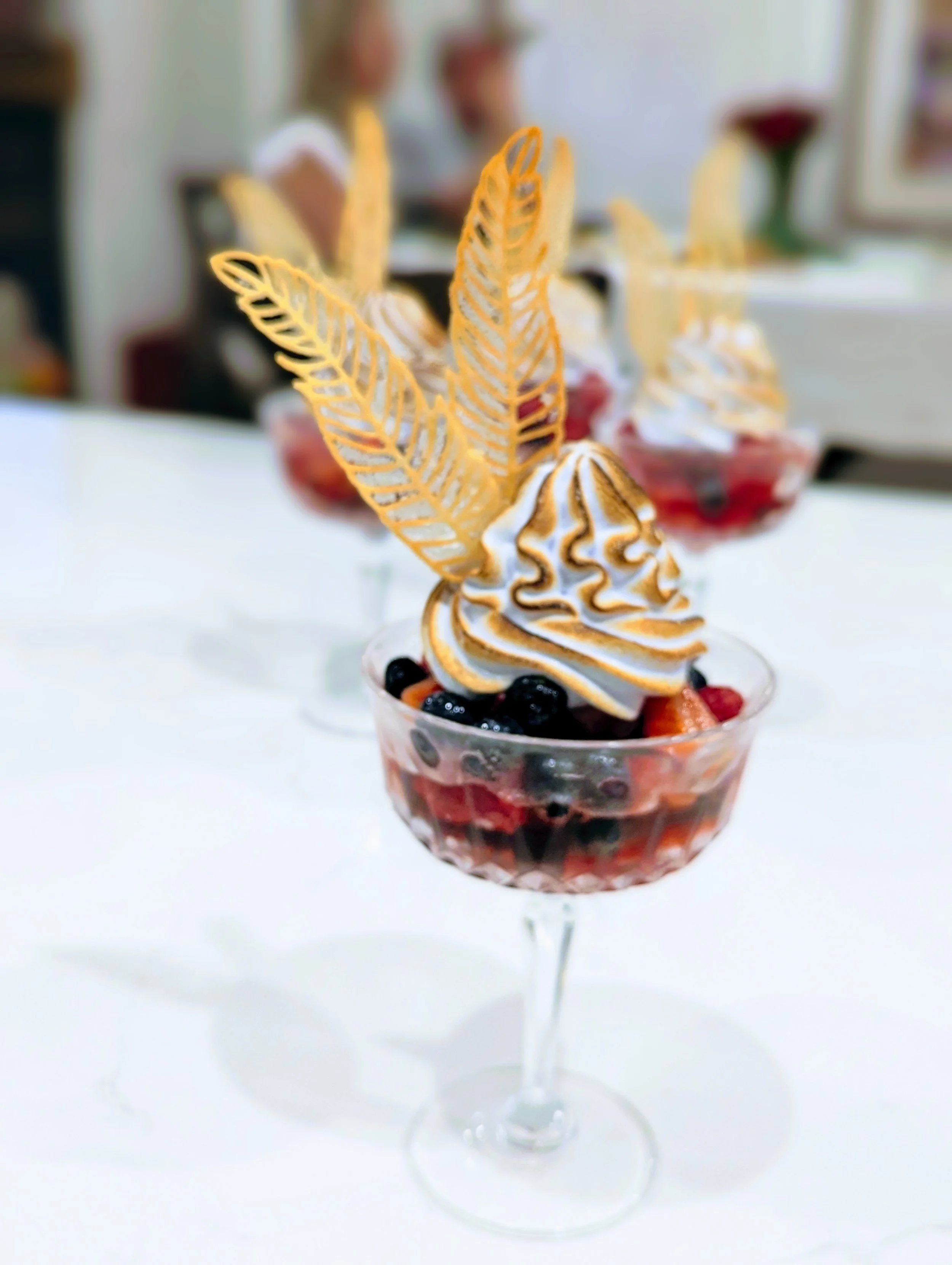 Italian Meringue Berry Parfait with toasted whipped cream in a long stemmed glass