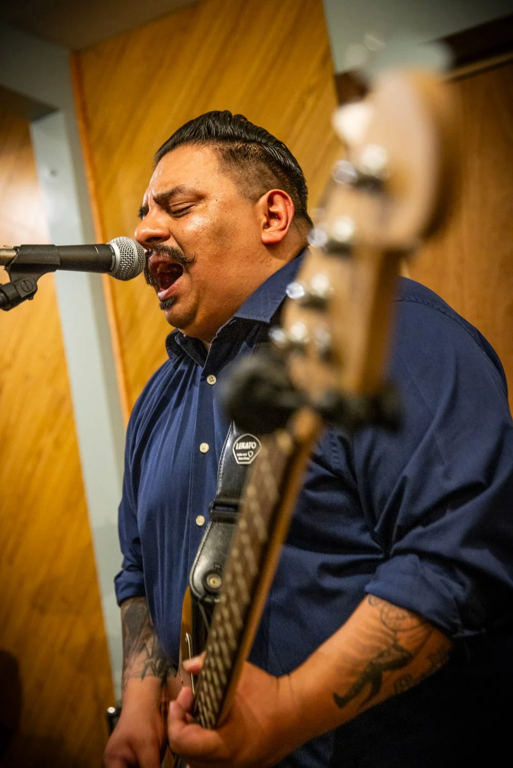 A close up of Bernard singing during rehearsal