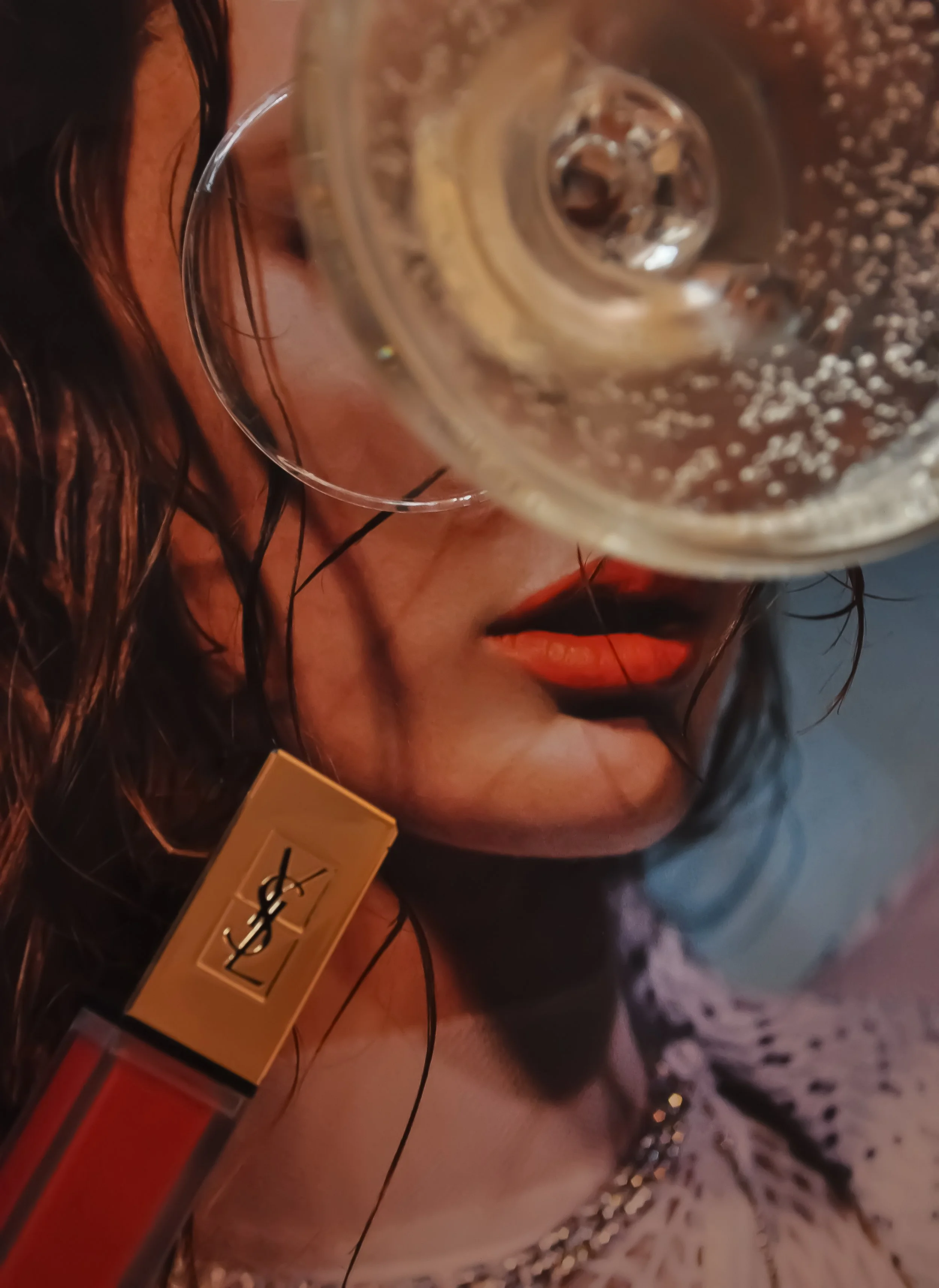 Close-up of a woman's face with red lips, partially obscured by a fizzy drink in a glass, and a gold-capped lipstick in the foreground.