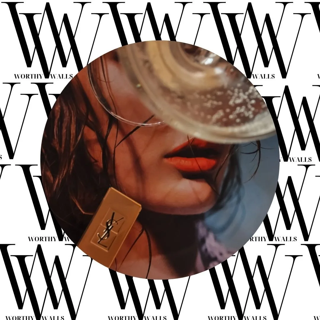 Close-up of a woman wearing bright red YSL lipstick partially visible, with a champagne glass near the face, overlay on "Worthy Walls" background.