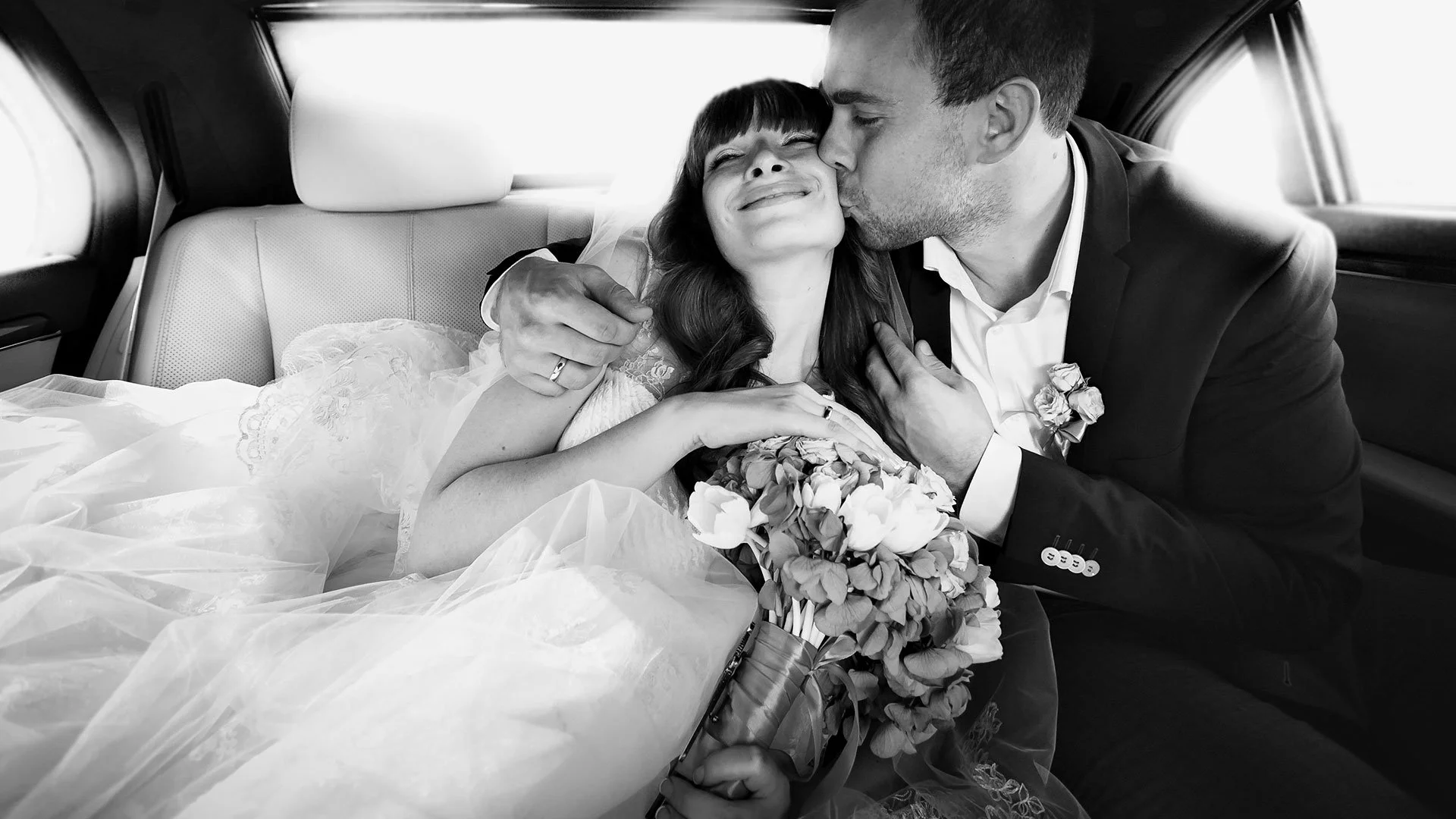 Bride and Groom in the back seat of a Limo