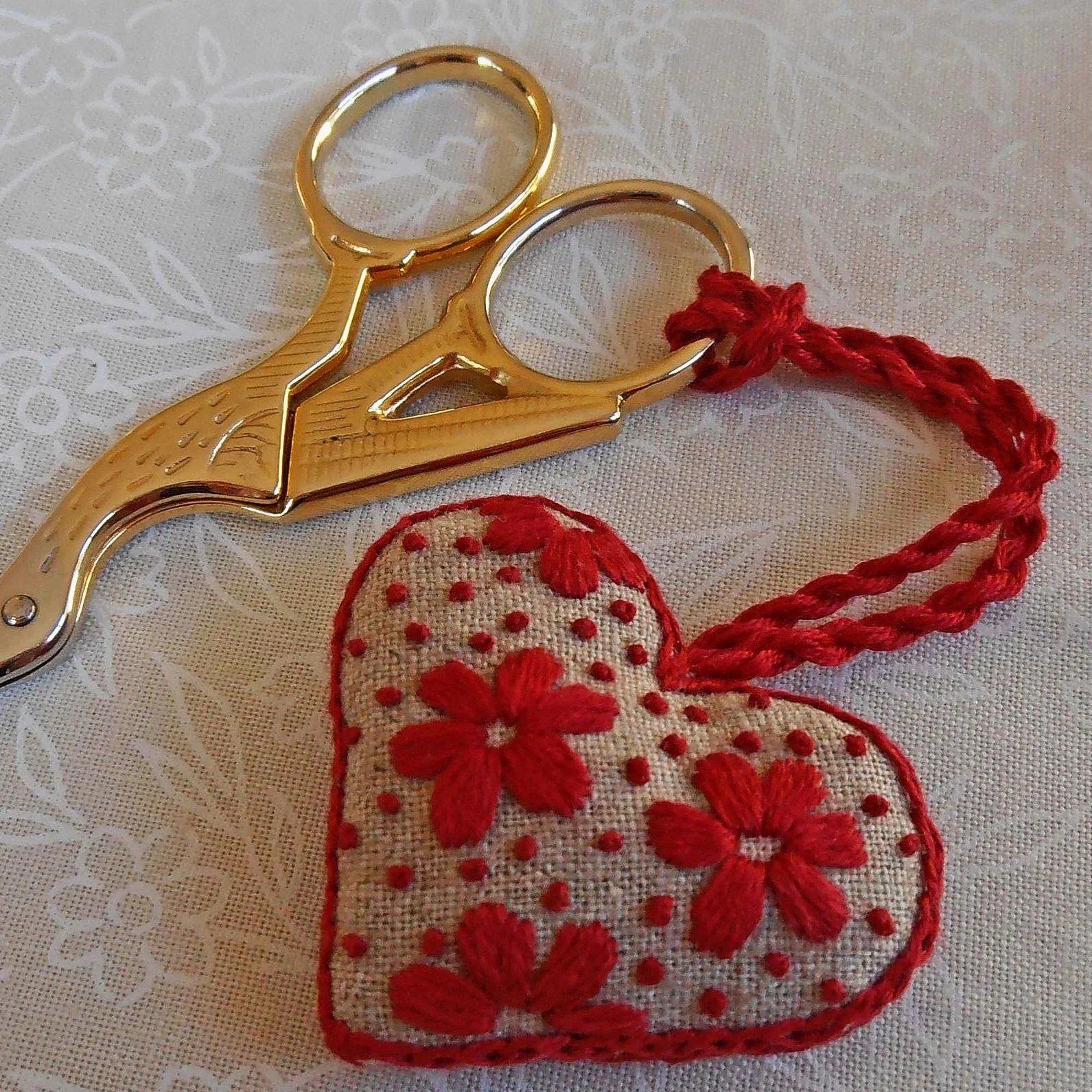 Embroidered heart-shaped scissor fob. Red flowers on linen