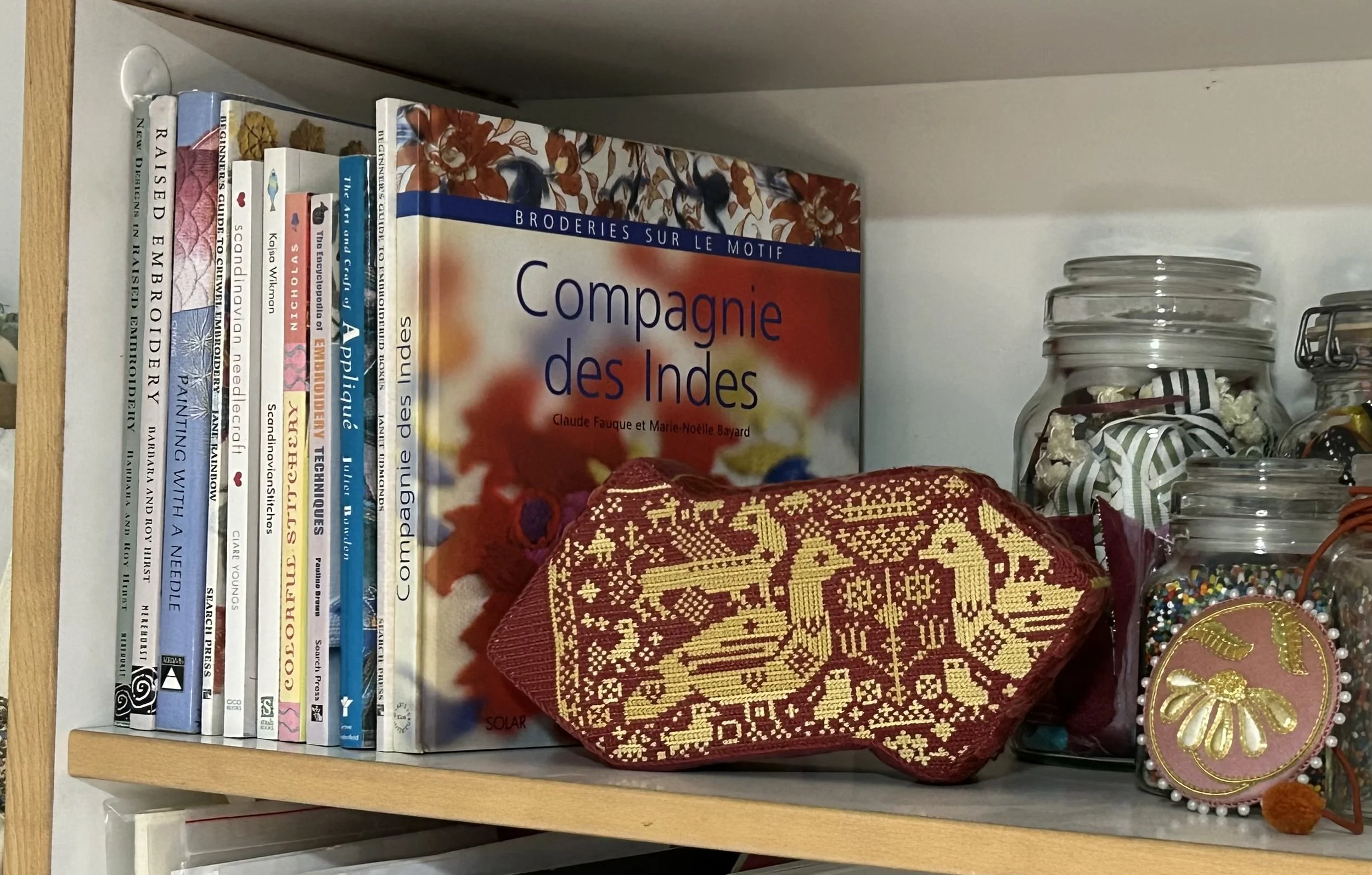 Book shelf with embroidery books. Book end made from a brick covered with embroidery by Anna Scott