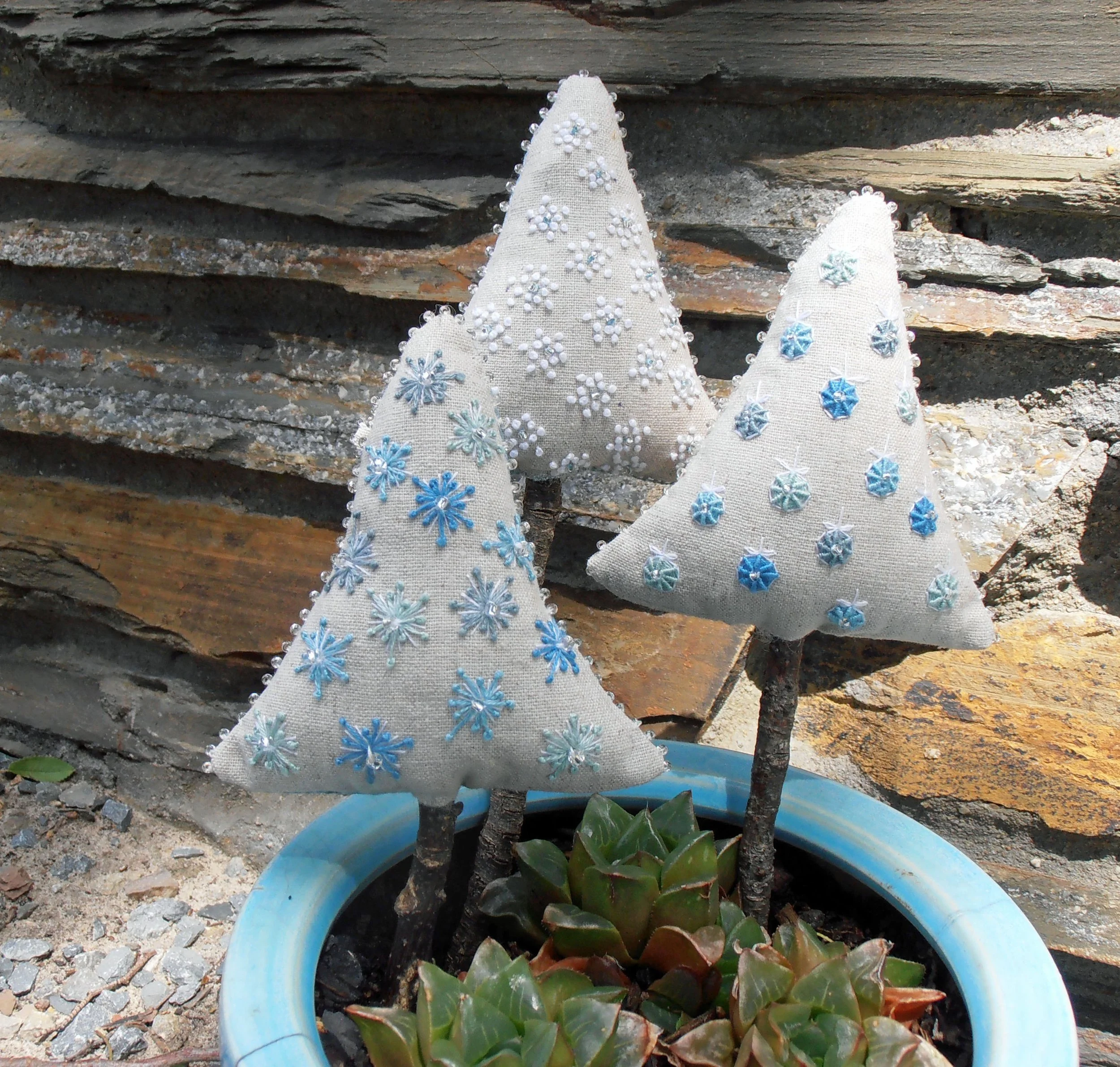 Small Christmas tree decorations made from linen with simple embroidery.