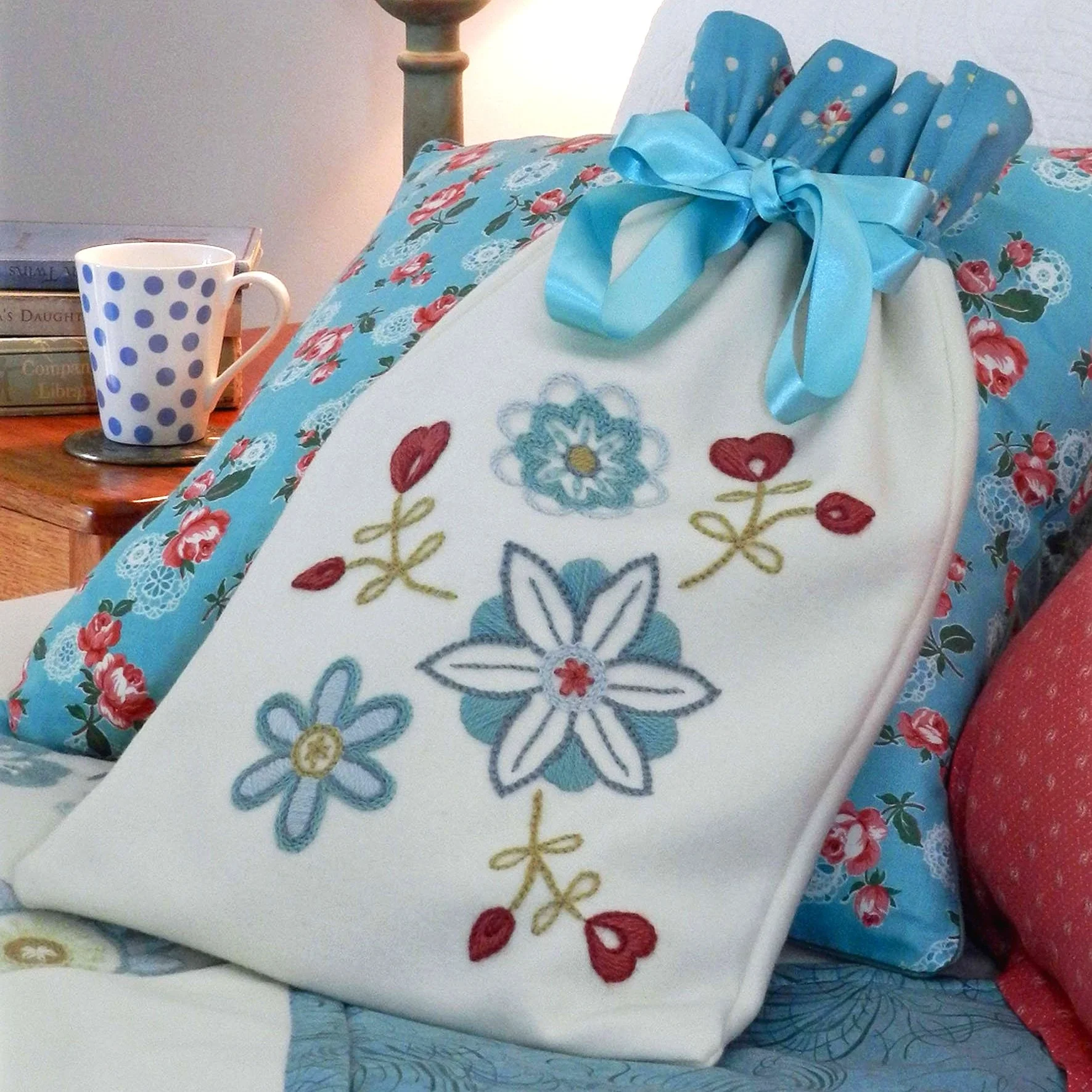 Woollen hot water bottle bag decorated with embroidered flowers.