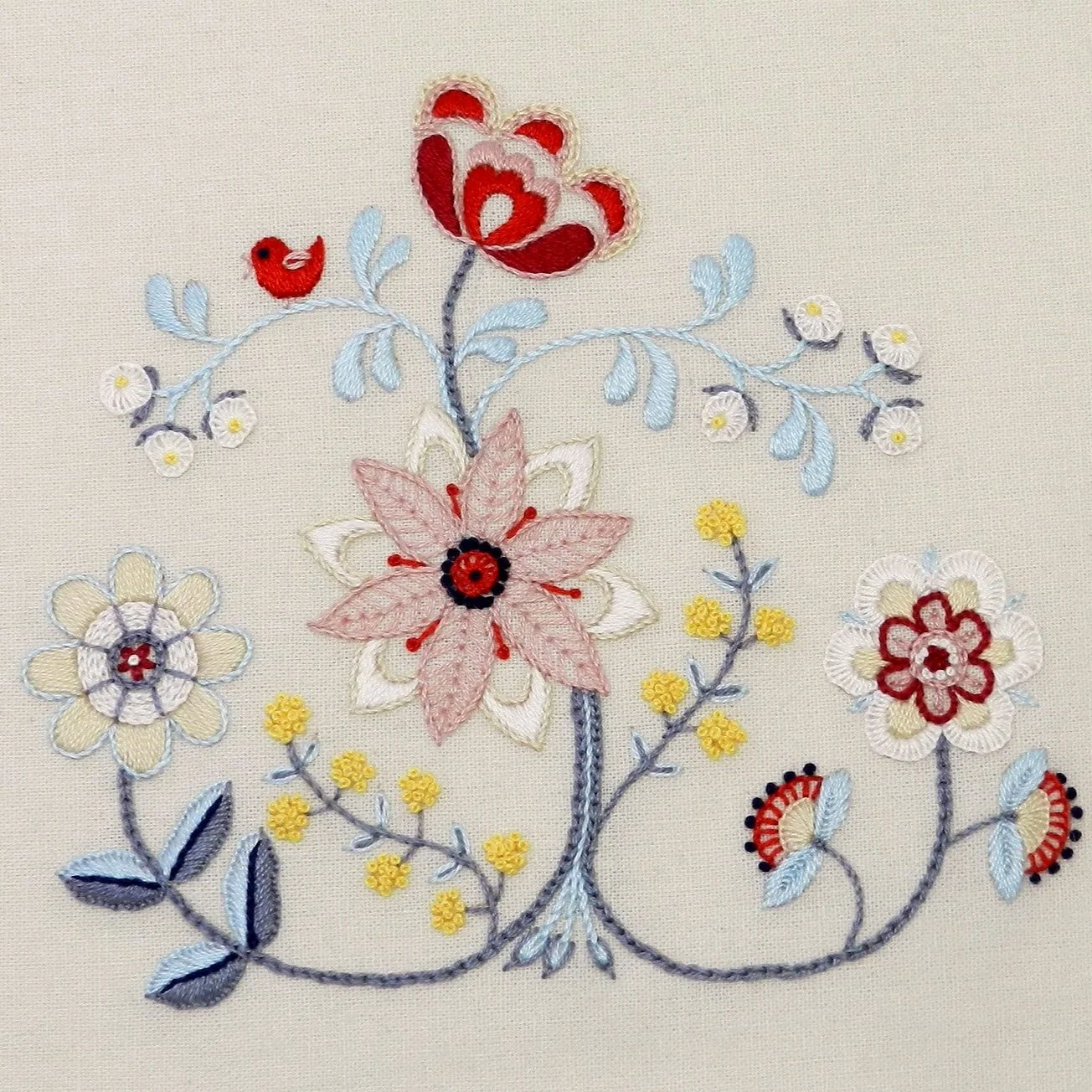 Hand embroidery. Scandinavian style flowers in shades of white, blue and red.