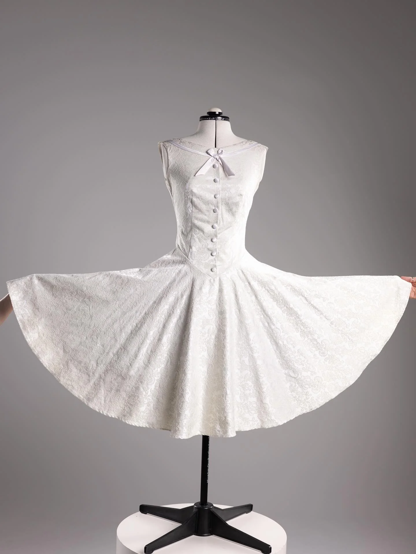 This exquisite cream brocade dress from Kitten D&rsquo;Amour is a numbered limited edition&mdash;No. 34 of only 200 made. Featuring a classic fit-and-flare silhouette, it boasts a beautifully tailored bodice, full circular skirt, and soft cotton-span