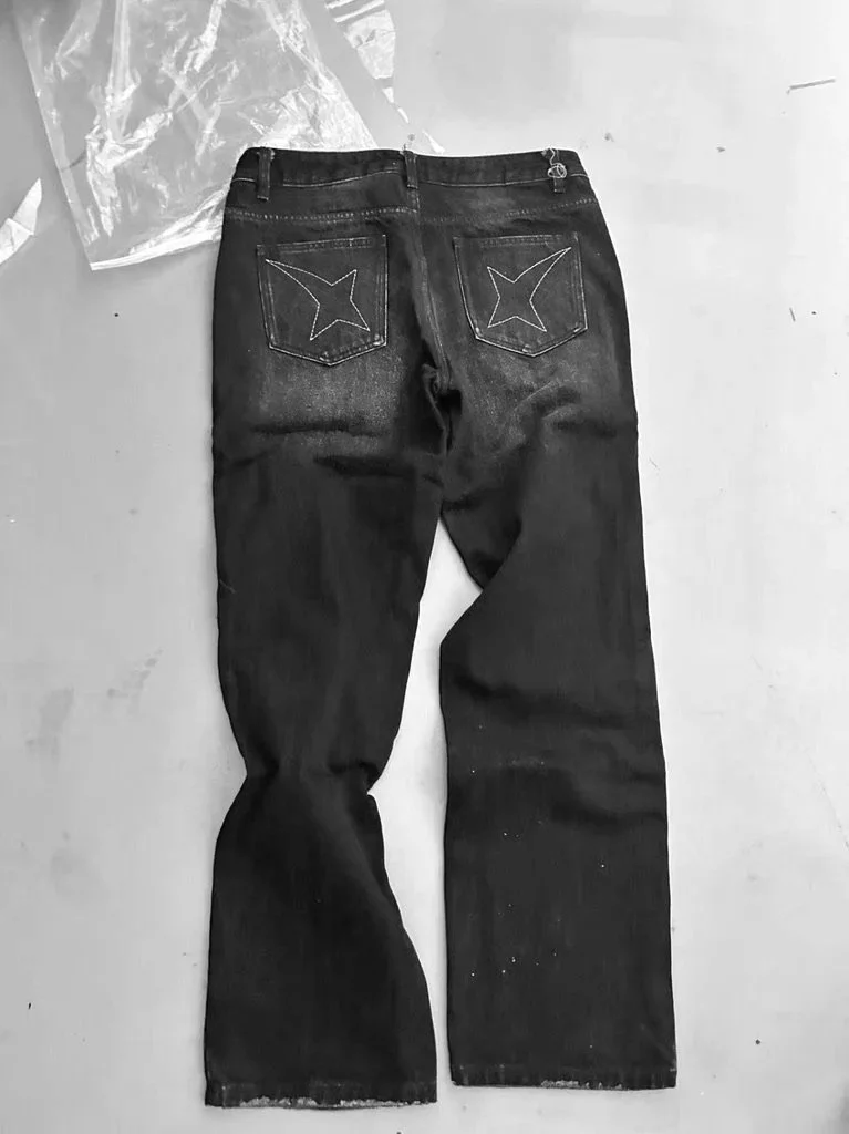 Back view of a pair of dark jeans laid flat on a surface.